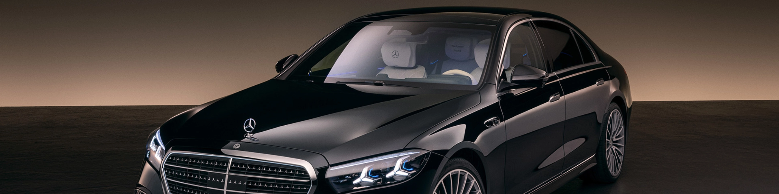 Eine schwarze Luxuslimousine der Mercedes-Benz S-Klasse steht im Studio mit weicher Beleuchtung.