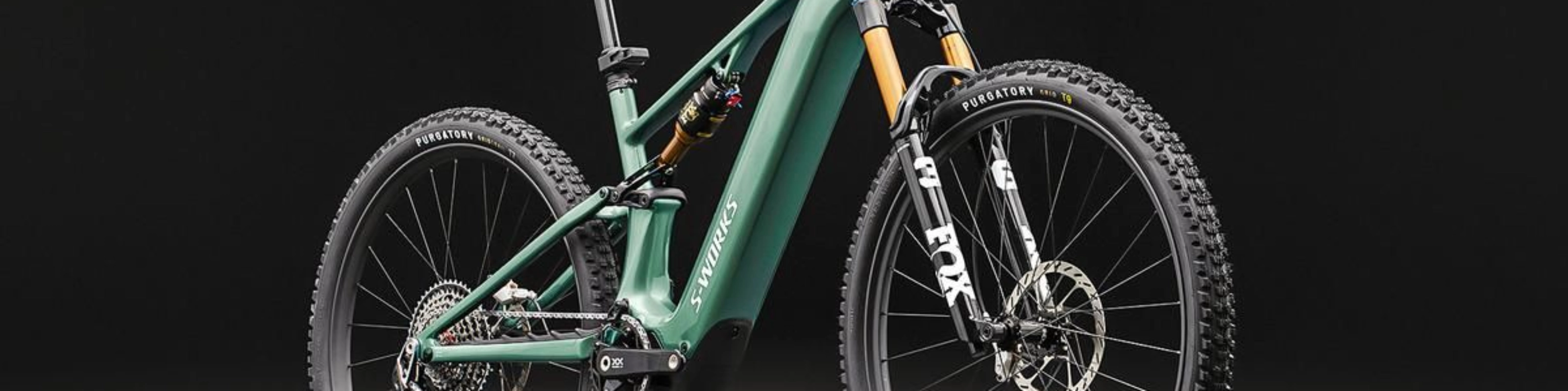 Green full-suspension mountain bike on a dark background.