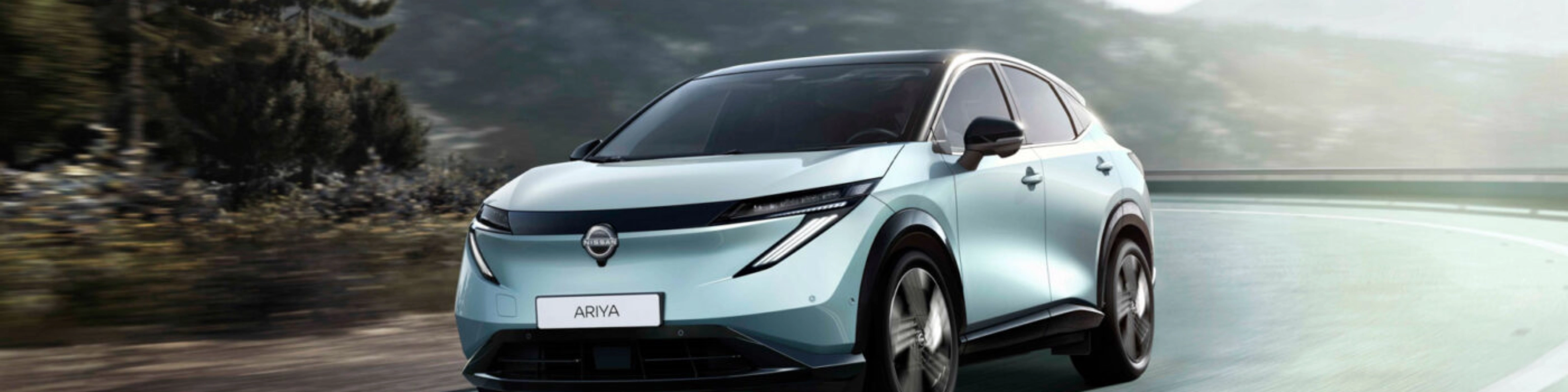 Nissan Ariya electric SUV driving on a mountain road.