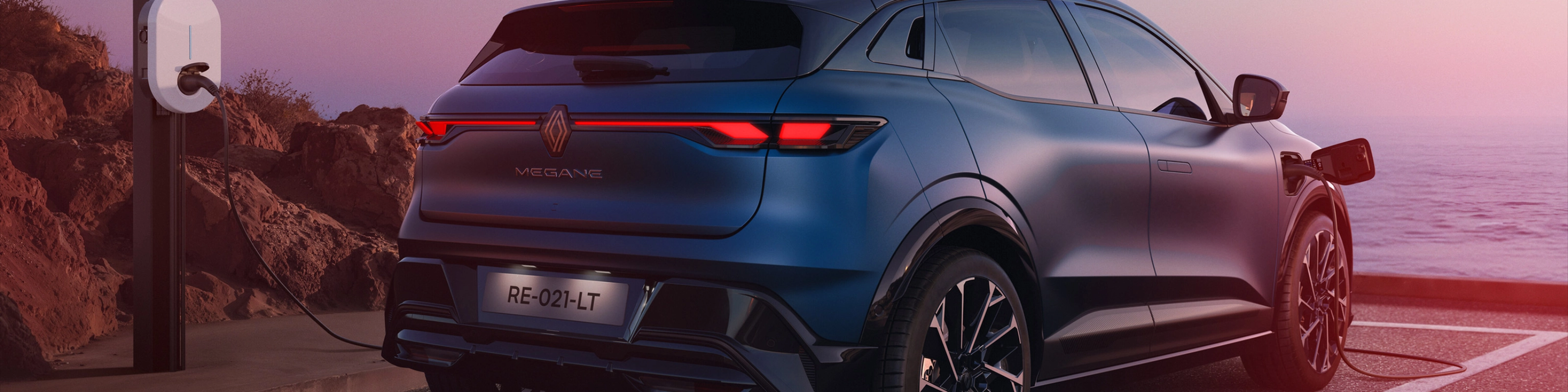 Heckansicht eines Renault Megane E-Tech beim Laden an einer E-Ladestation.