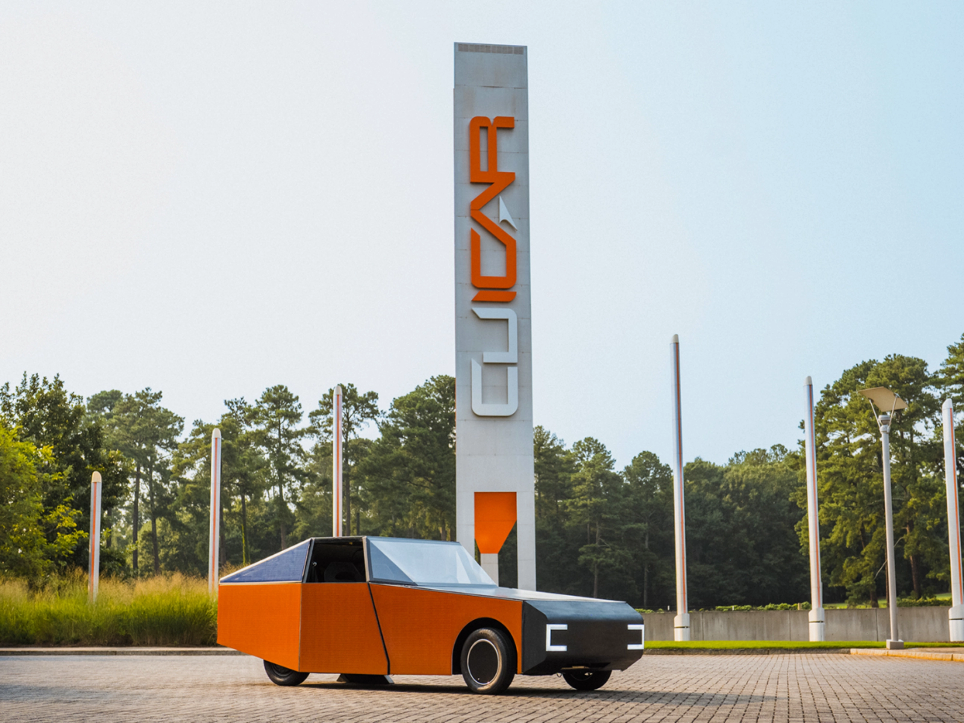 Autonomous vehicle beside a CU-ICAR test tower at Clemson University.
