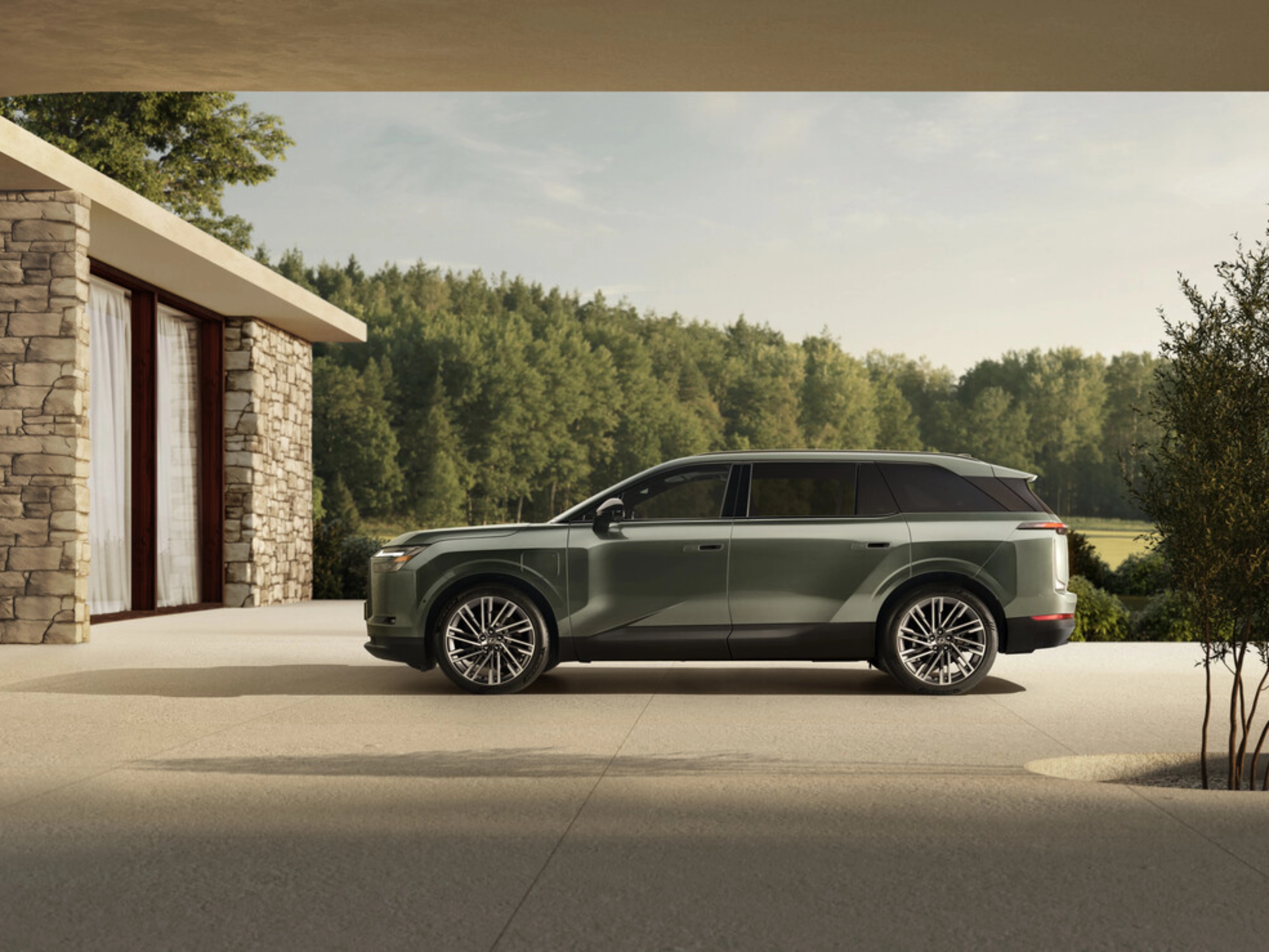 Grünes Toyota Elektro-SUV neben modernem Steinhaus geparkt.
