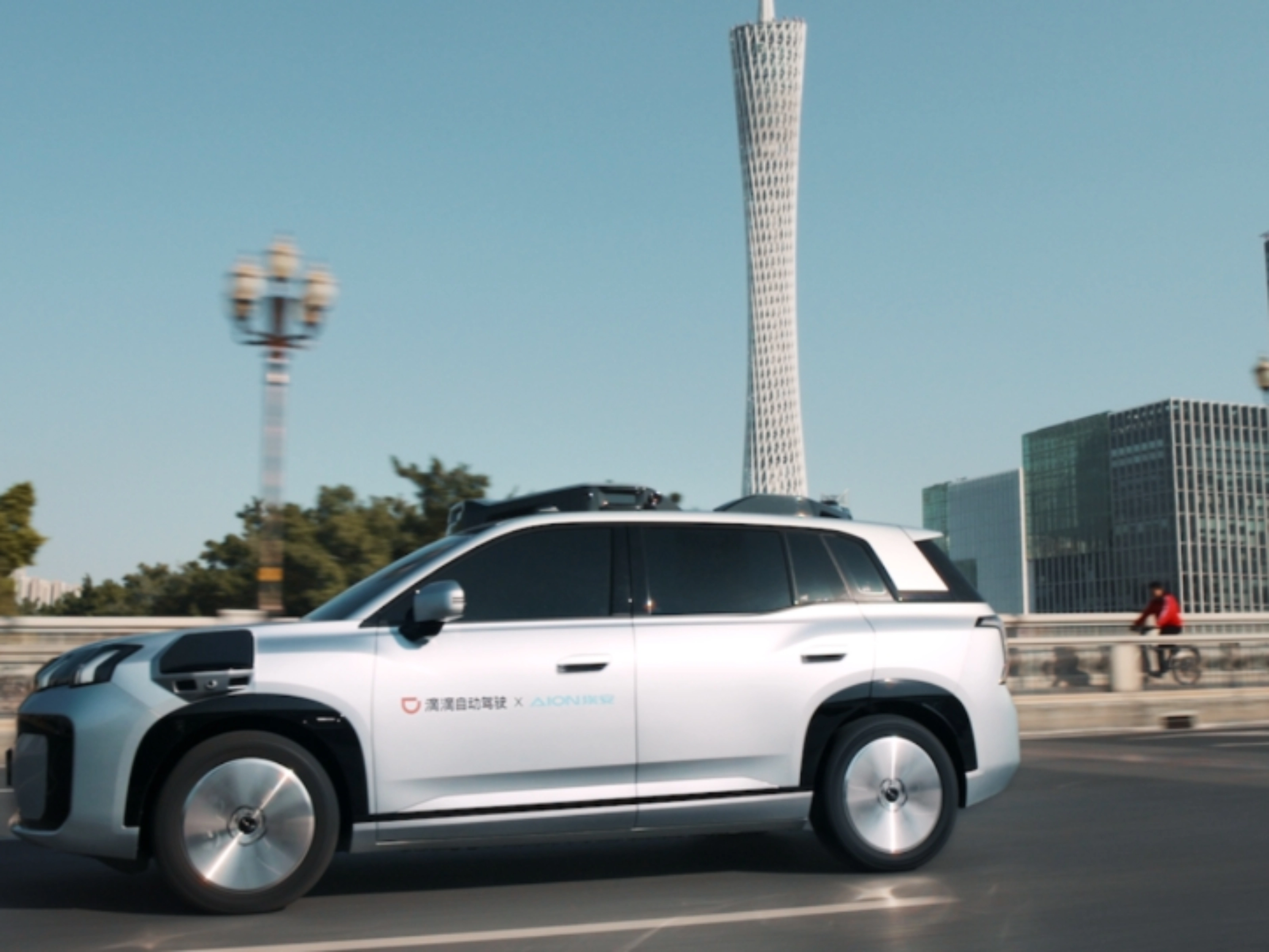 Ein autonomes SUV fährt durch eine Stadt mit modernen Gebäuden im Hintergrund.