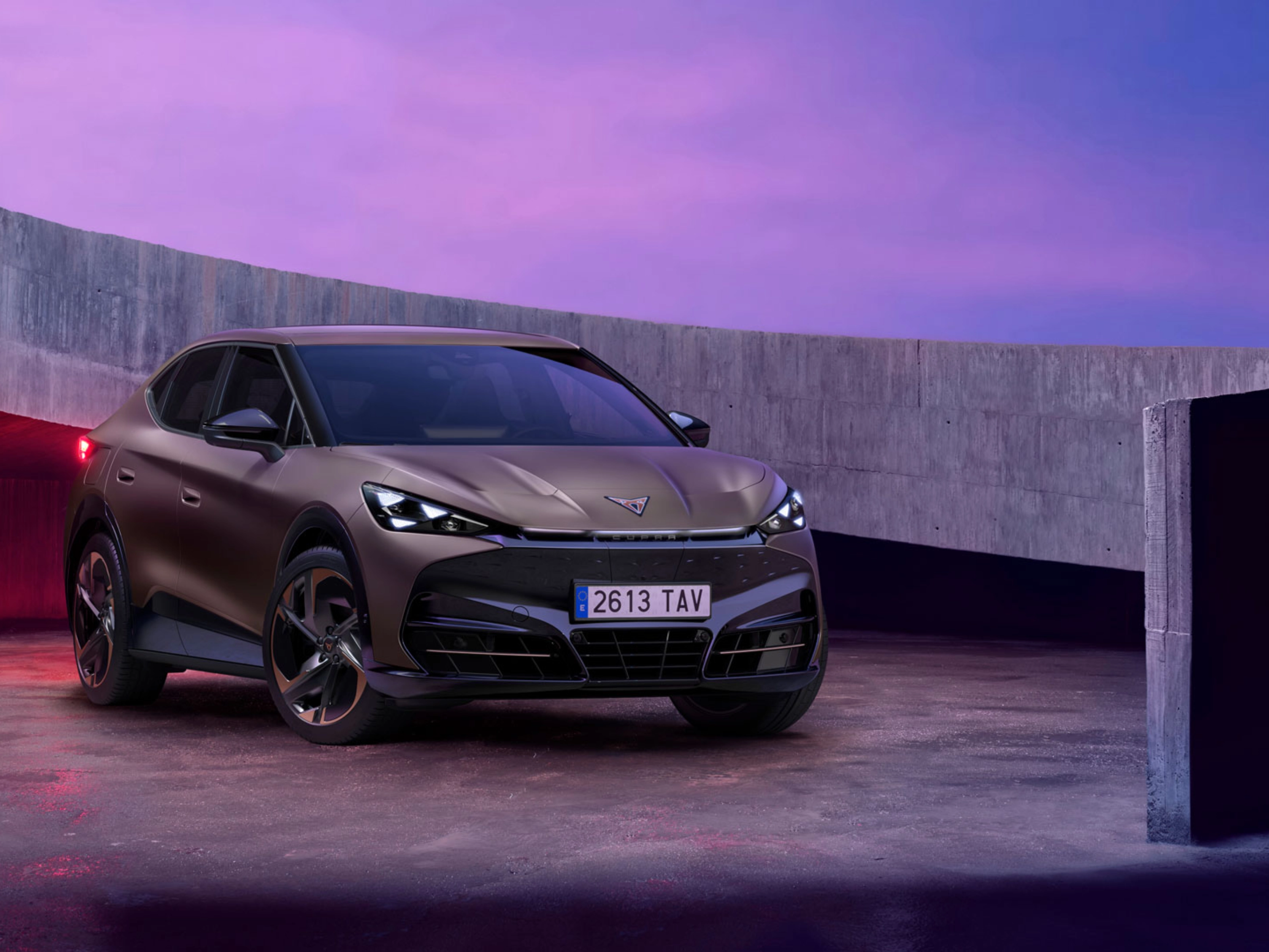 Cupra car parked in modern concrete setting with purple lighting.