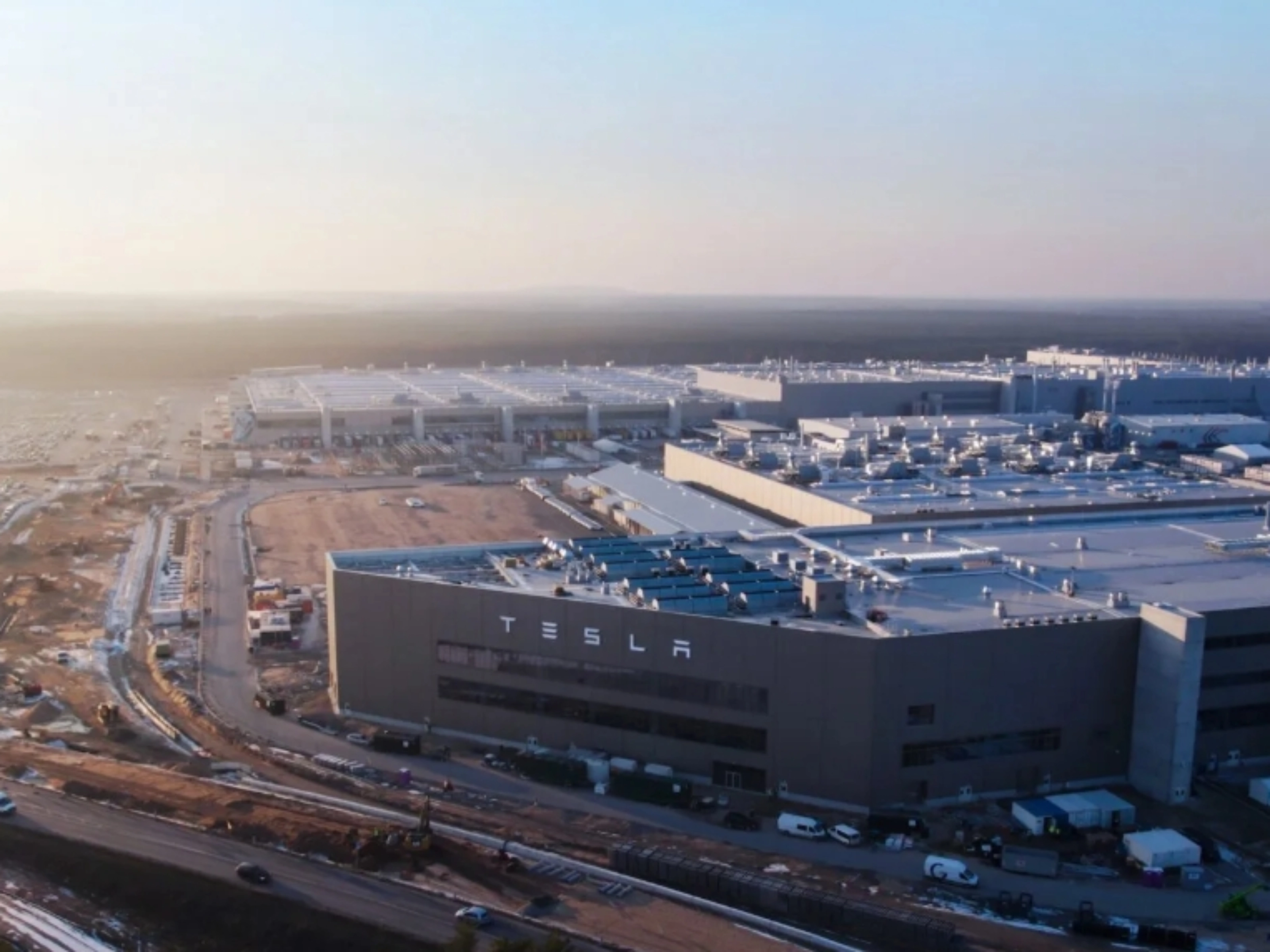 Luftaufnahme eines Tesla-Werks mit großen Produktionsgebäuden.