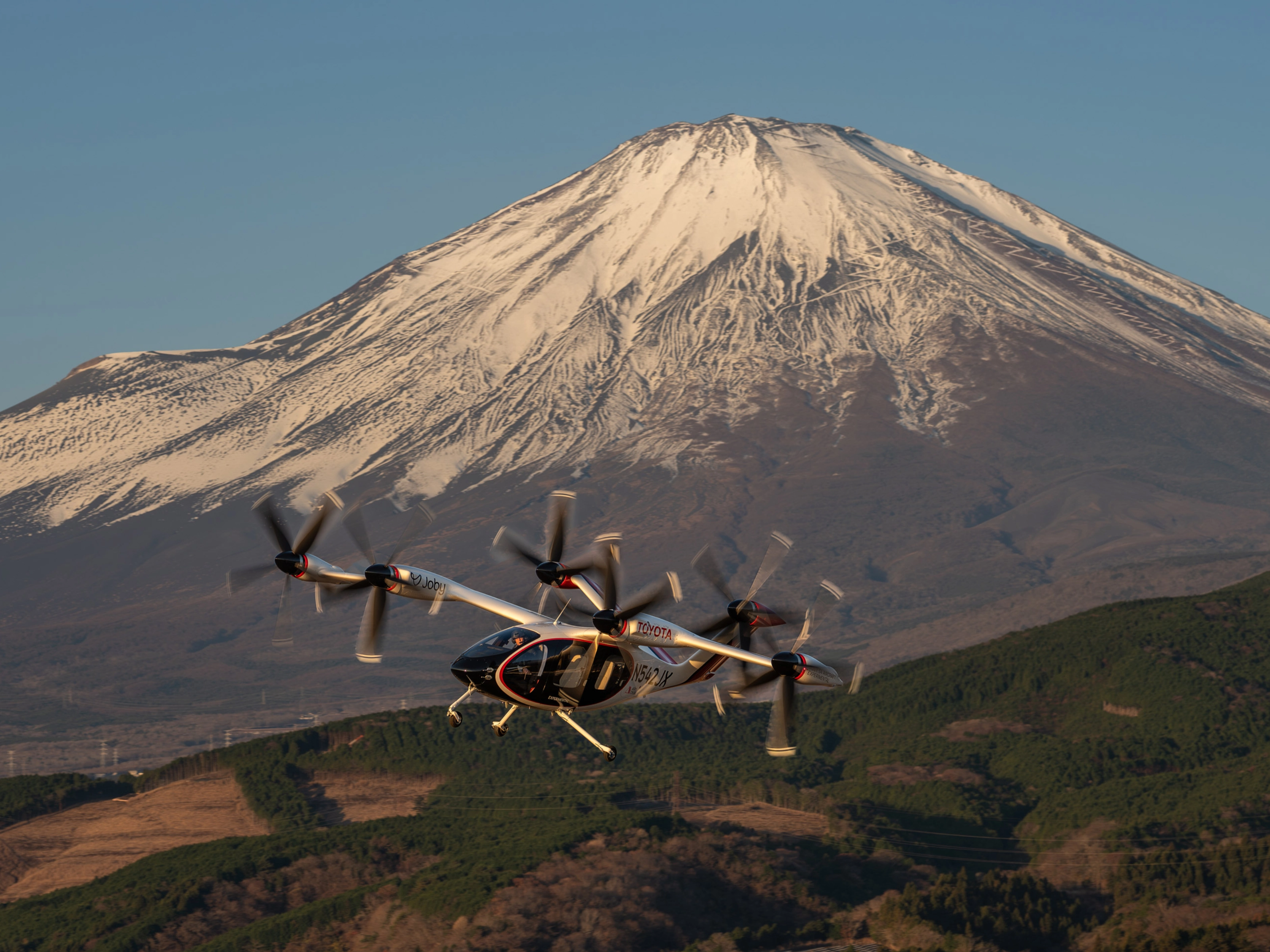 Elektrisches Flugtaxi von Joby Aviation vor dem Berg Fuji im Flug.