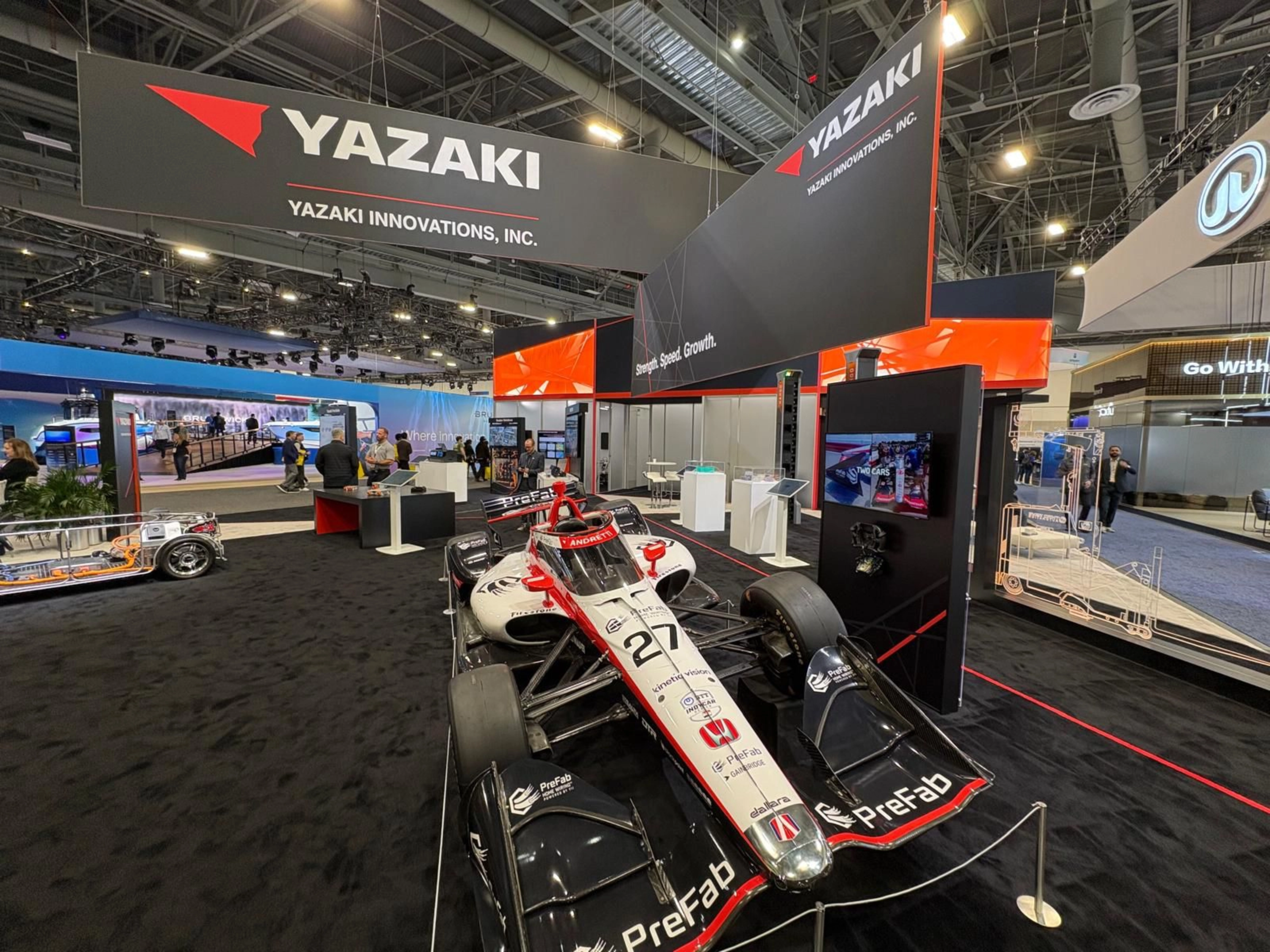 Ein Rennwagen steht am Messestand von Yazaki auf einer Technologiemesse.