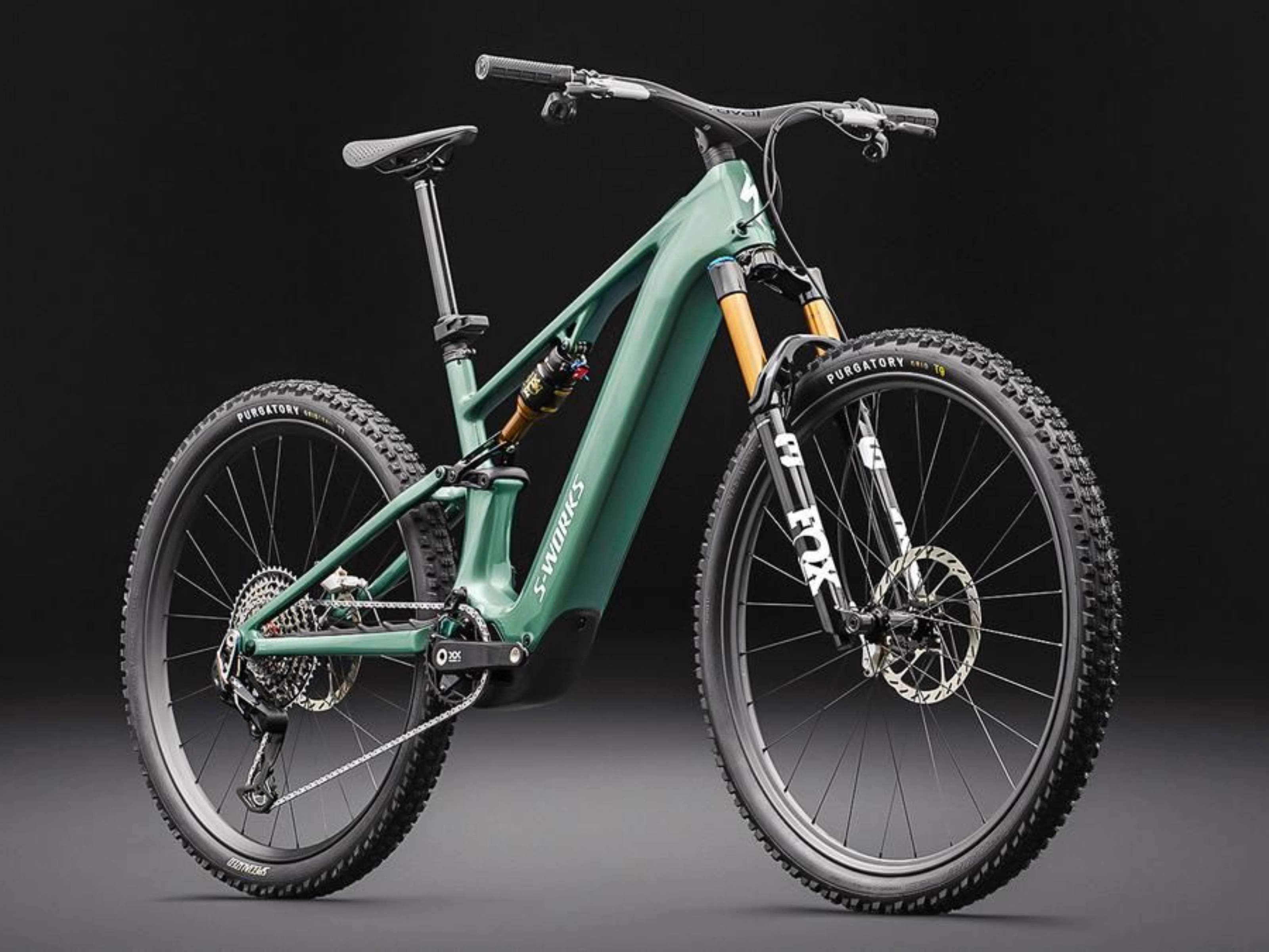 Green full-suspension mountain bike on a dark background.