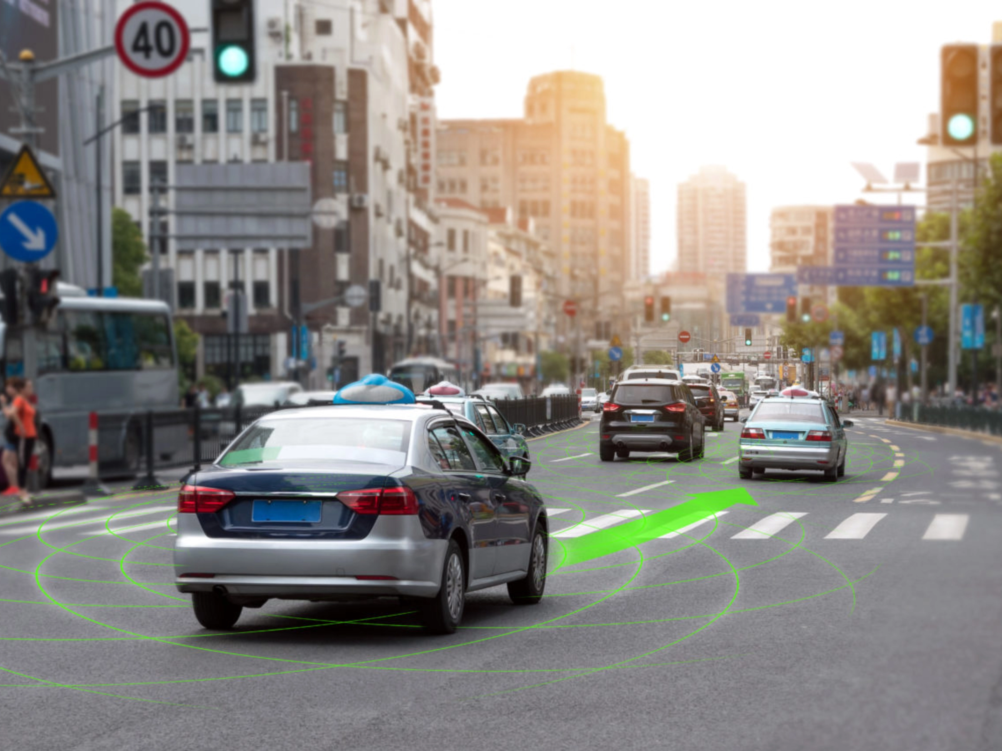 Car driving through a city street with lane guidance highlighted by driver assistance.