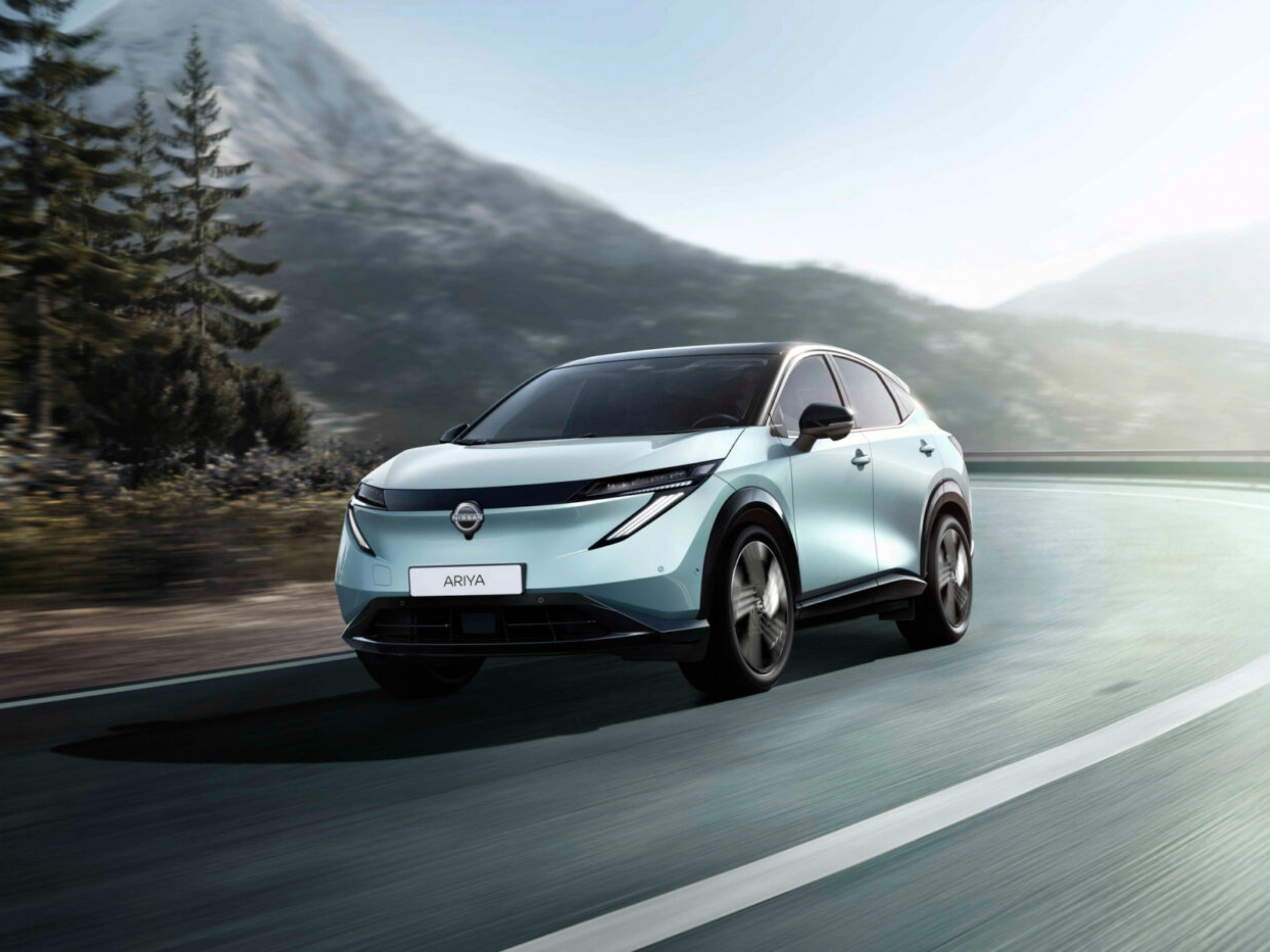 Nissan Ariya electric SUV driving on a mountain road.