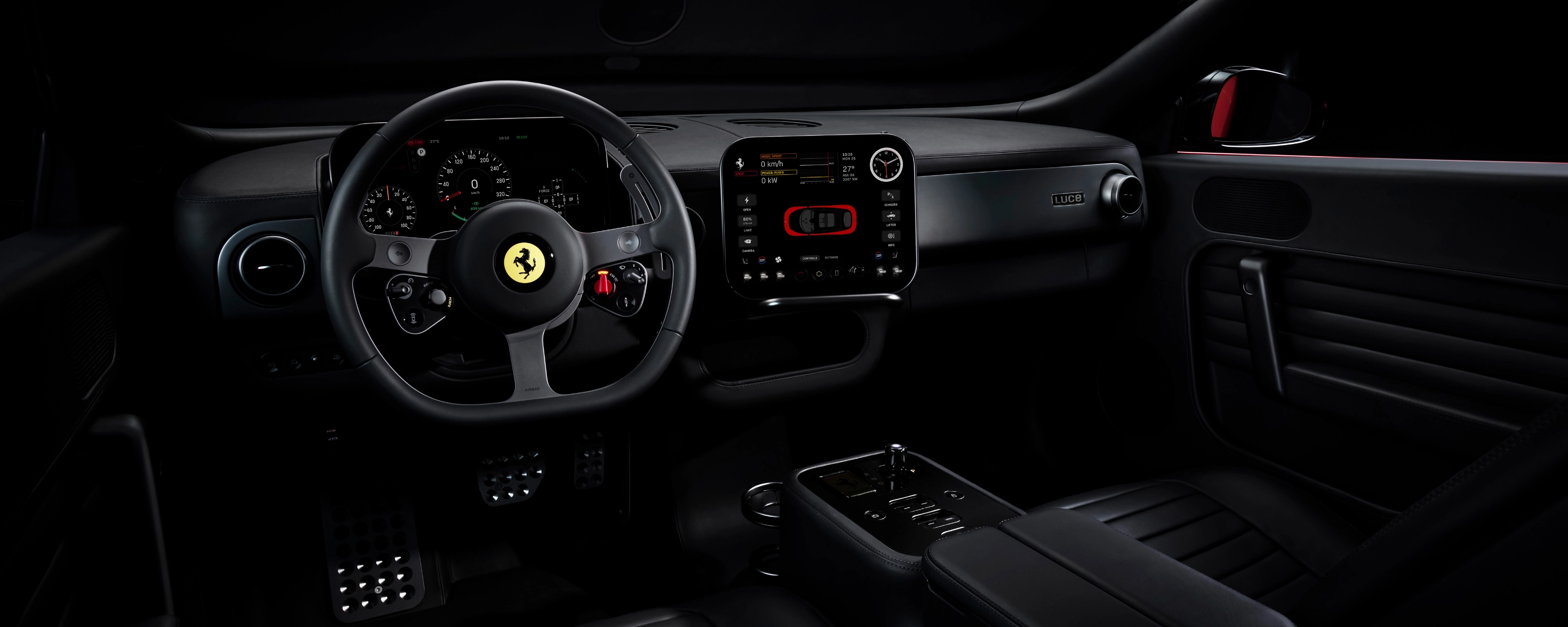 Dark Ferrari interior with illuminated dashboard and steering wheel.