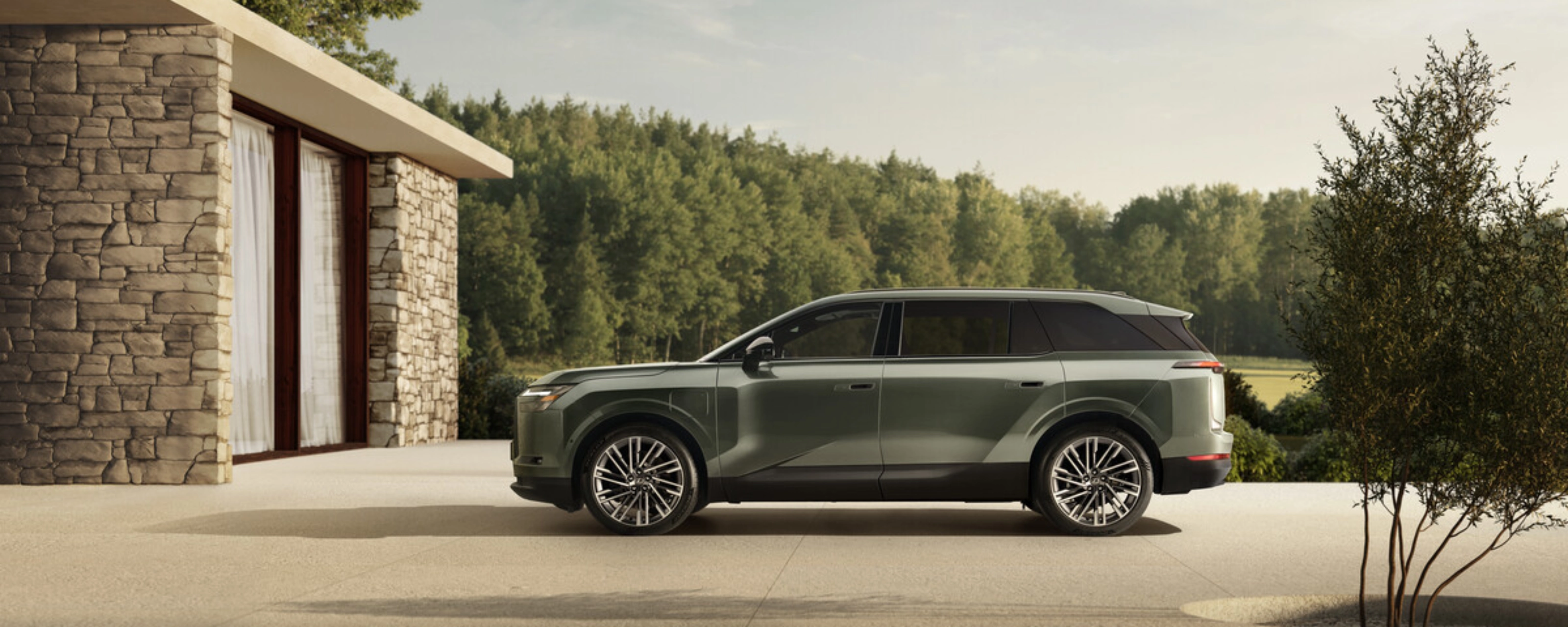 Grünes Toyota Elektro-SUV neben modernem Steinhaus geparkt.