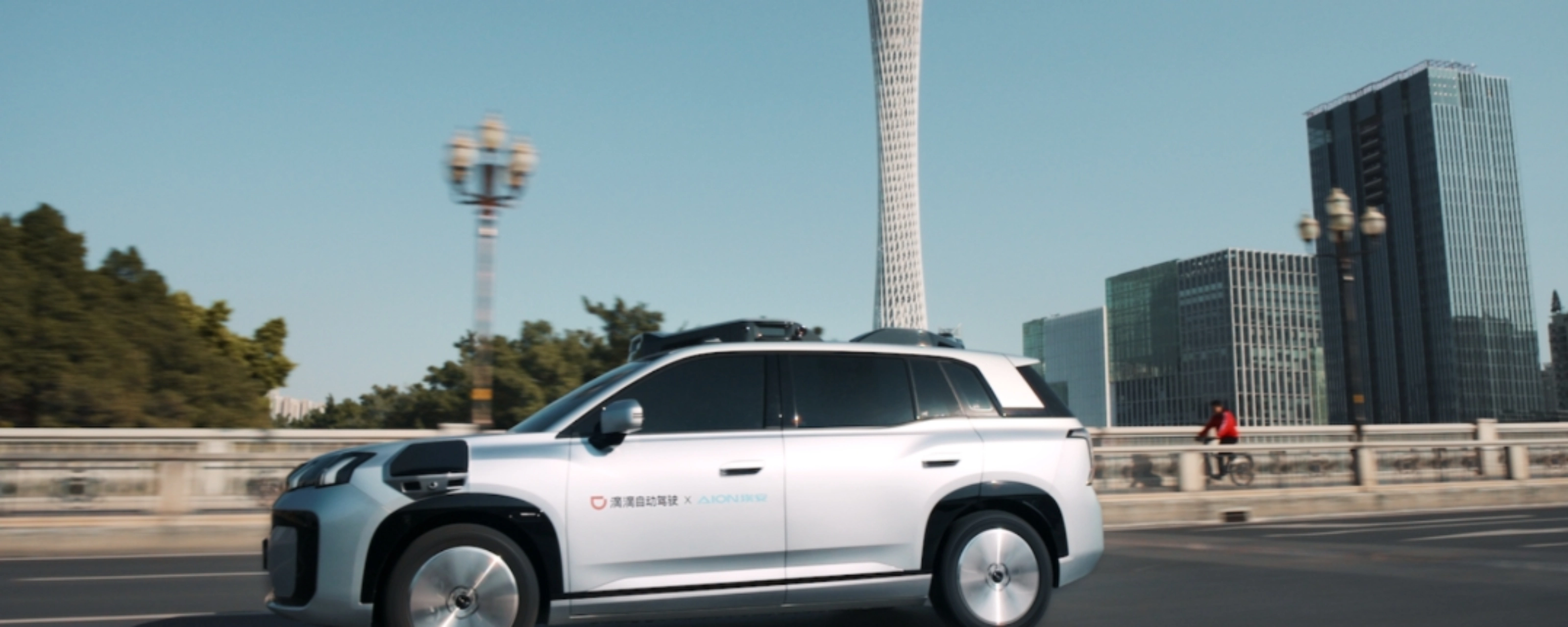 Ein autonomes SUV fährt durch eine Stadt mit modernen Gebäuden im Hintergrund.