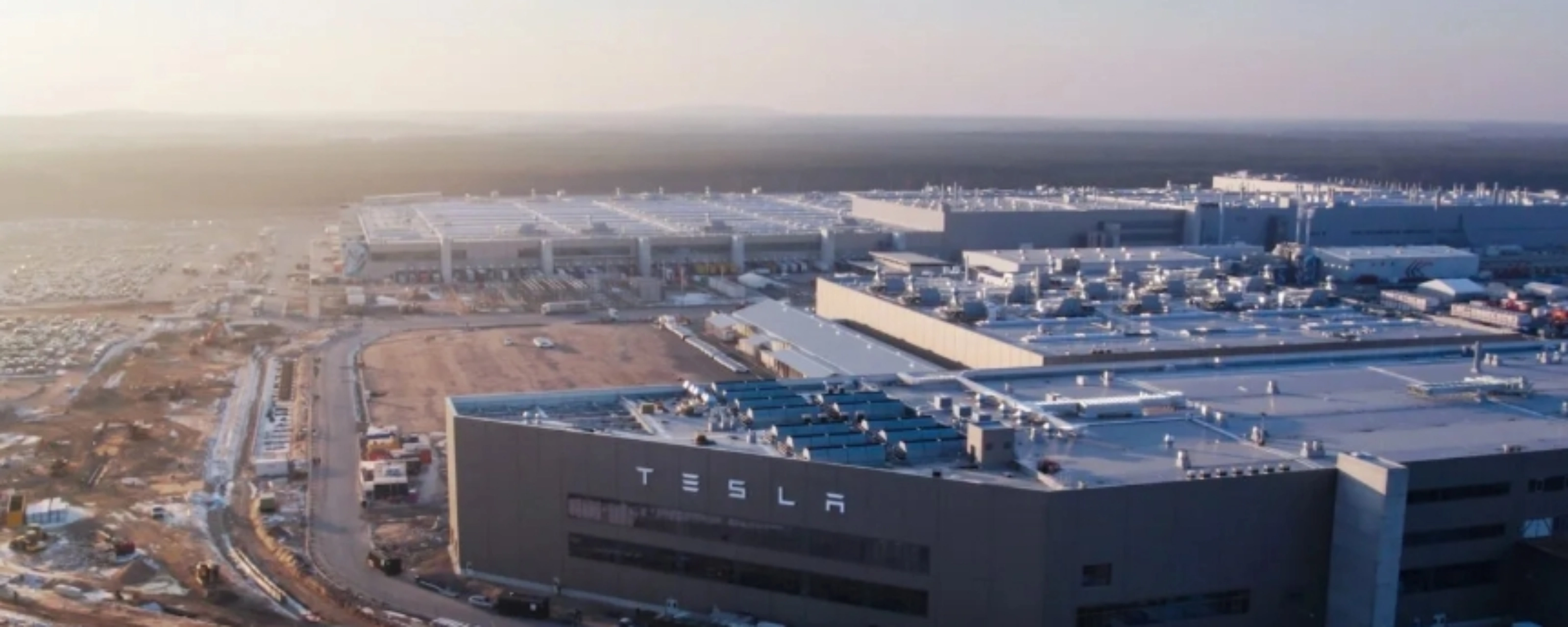 Luftaufnahme eines Tesla-Werks mit großen Produktionsgebäuden.
