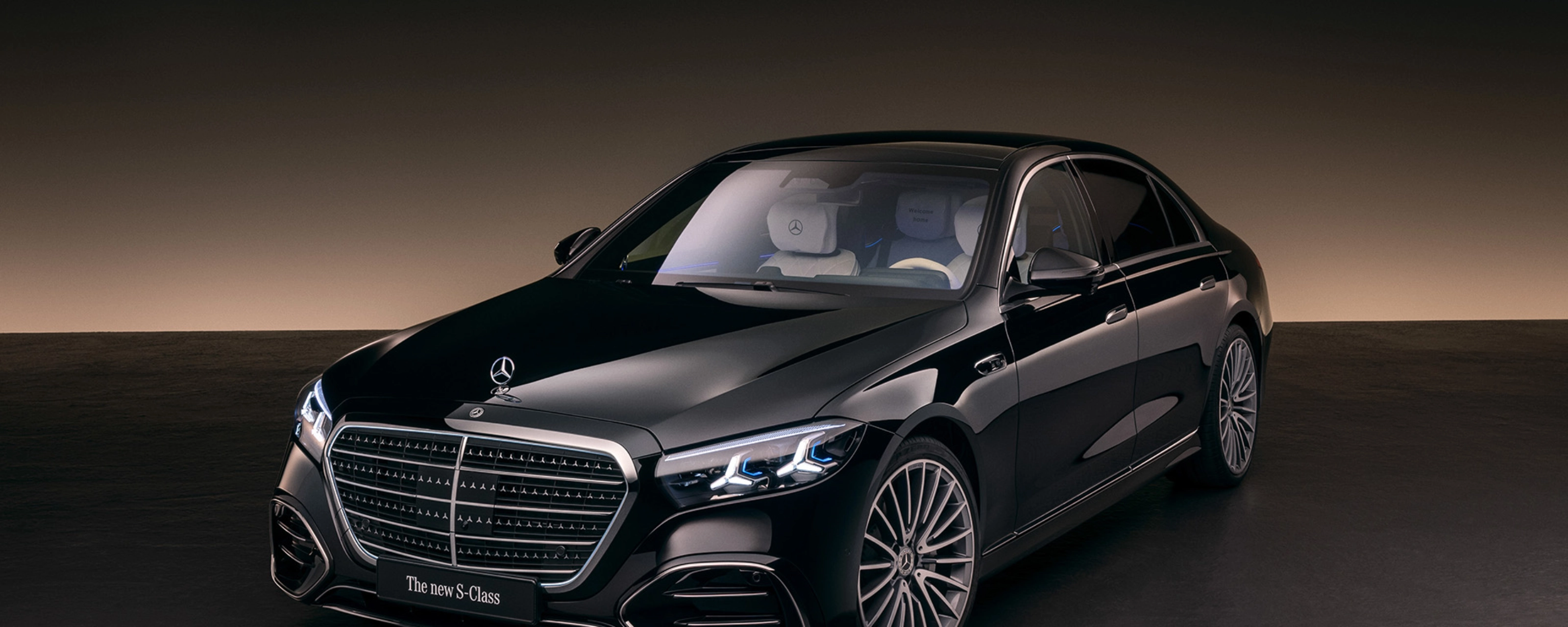 Eine schwarze Luxuslimousine der Mercedes-Benz S-Klasse steht im Studio mit weicher Beleuchtung.