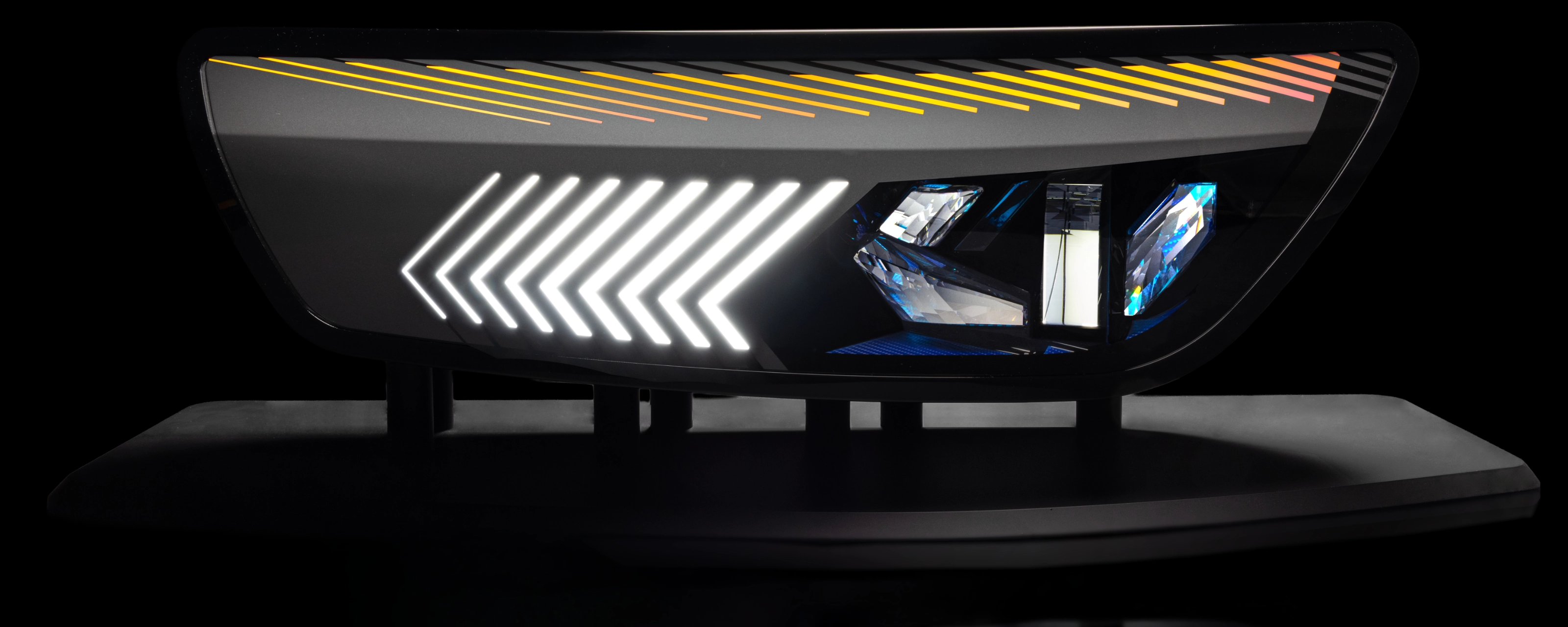 Close-up of a modern car tail light with animated red and yellow LED patterns.