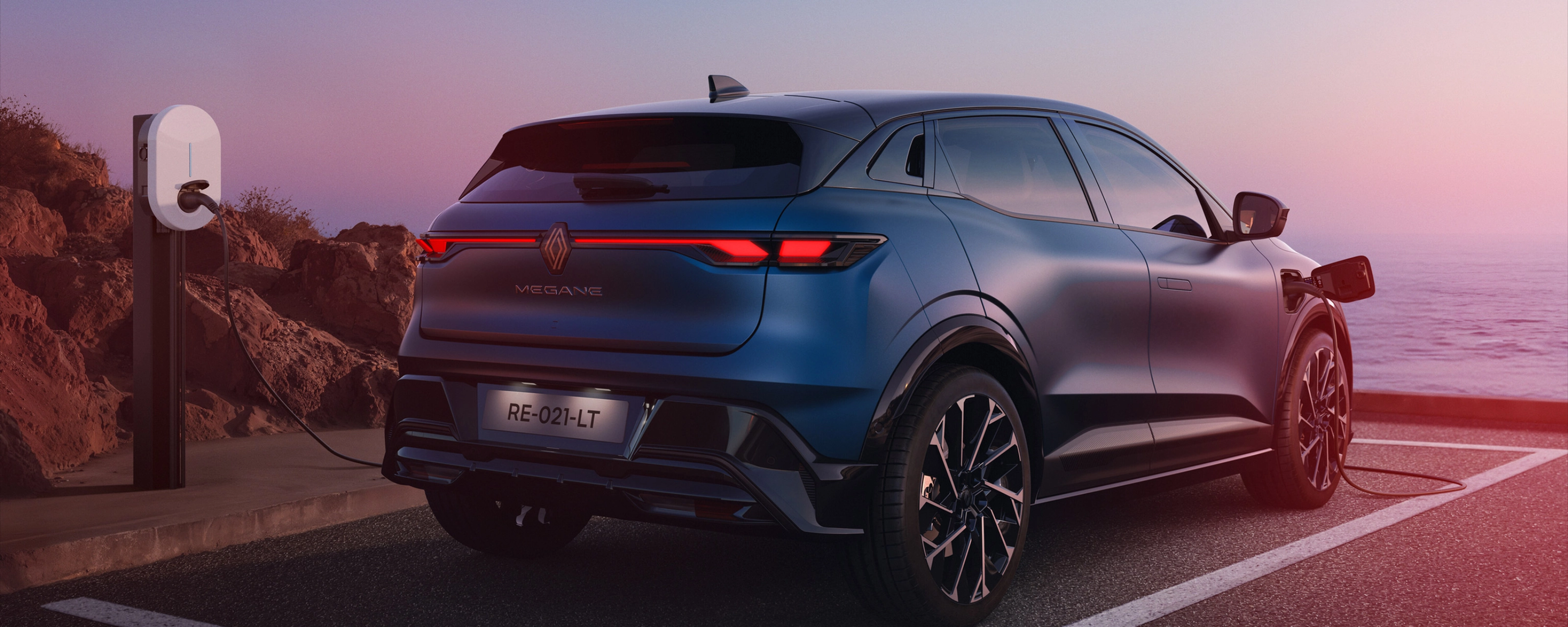 Heckansicht eines Renault Megane E-Tech beim Laden an einer E-Ladestation.