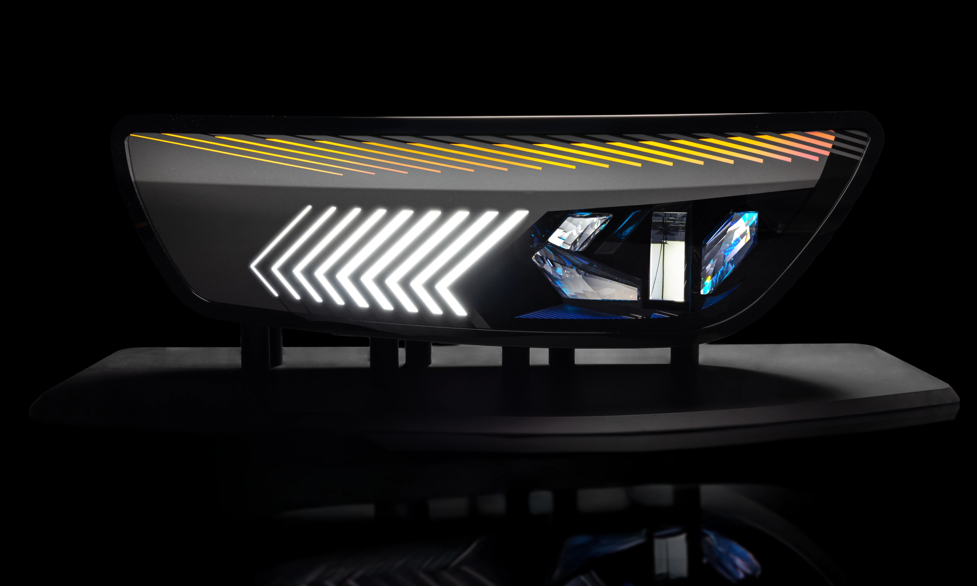 Close-up of a modern car tail light with animated red and yellow LED patterns.