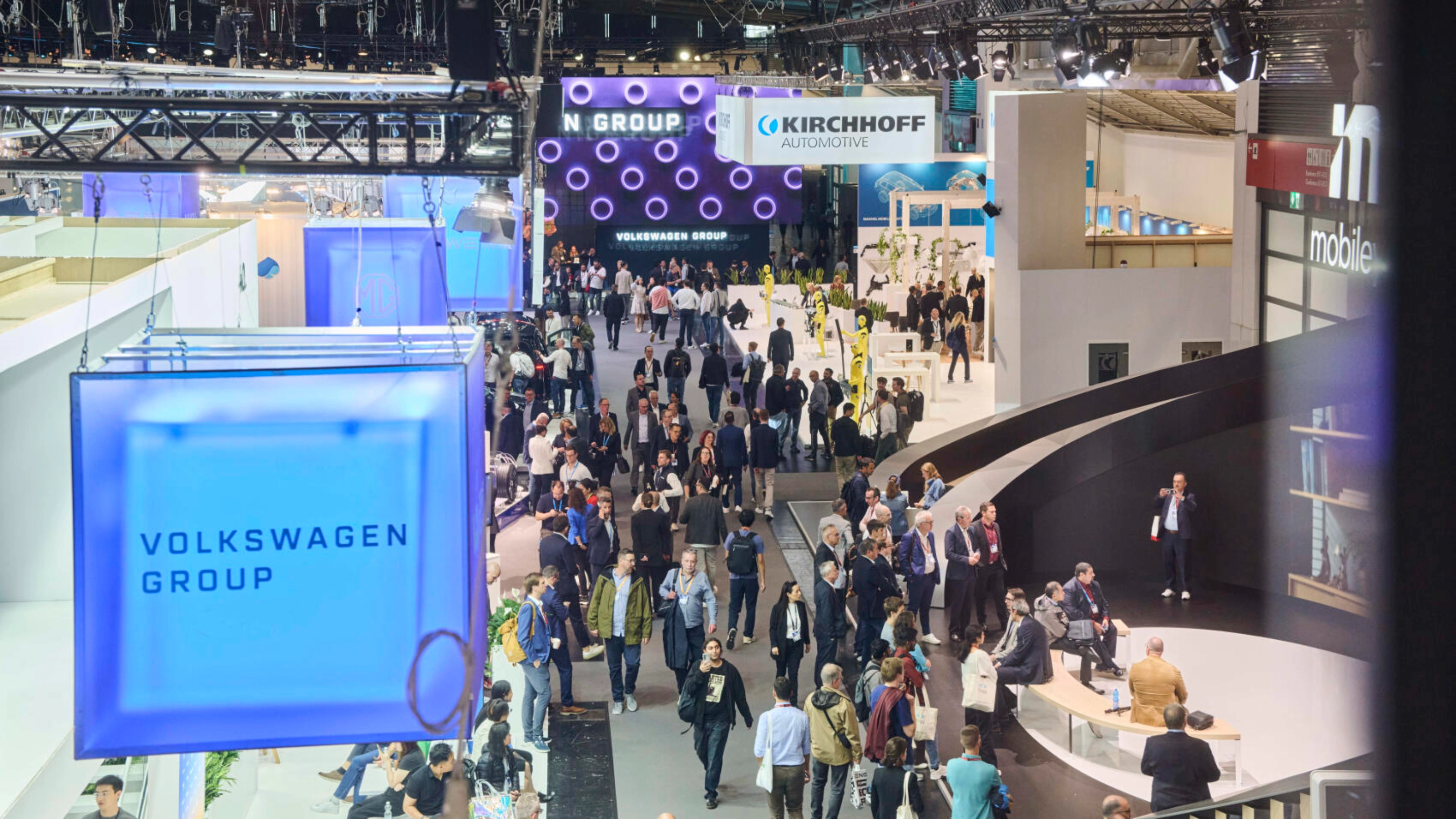 Menschen besuchen den Stand der Volkswagen Group auf einer Messe.