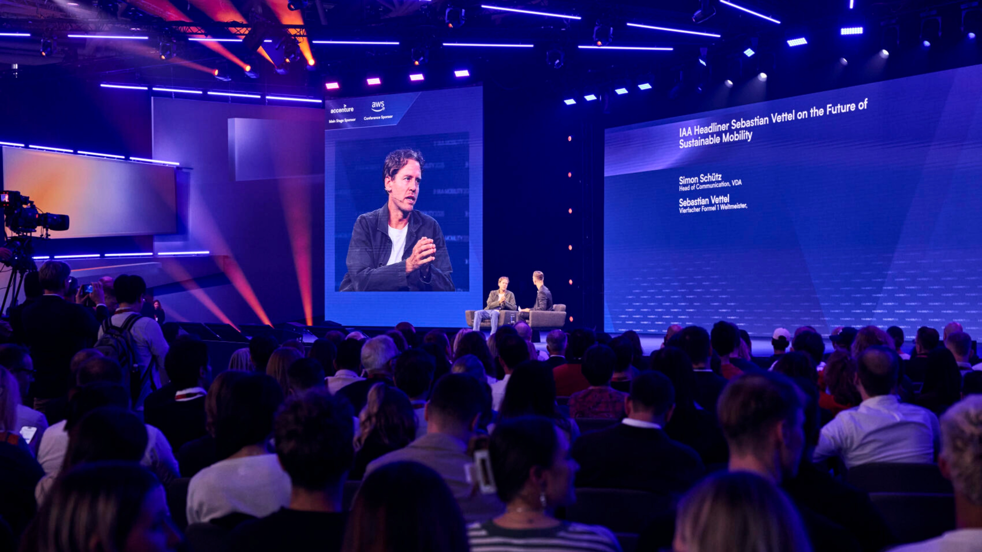 Publikum verfolgt eine Live-Bühnendiskussion zur nachhaltigen Mobilität mit Sebastian Vettel.