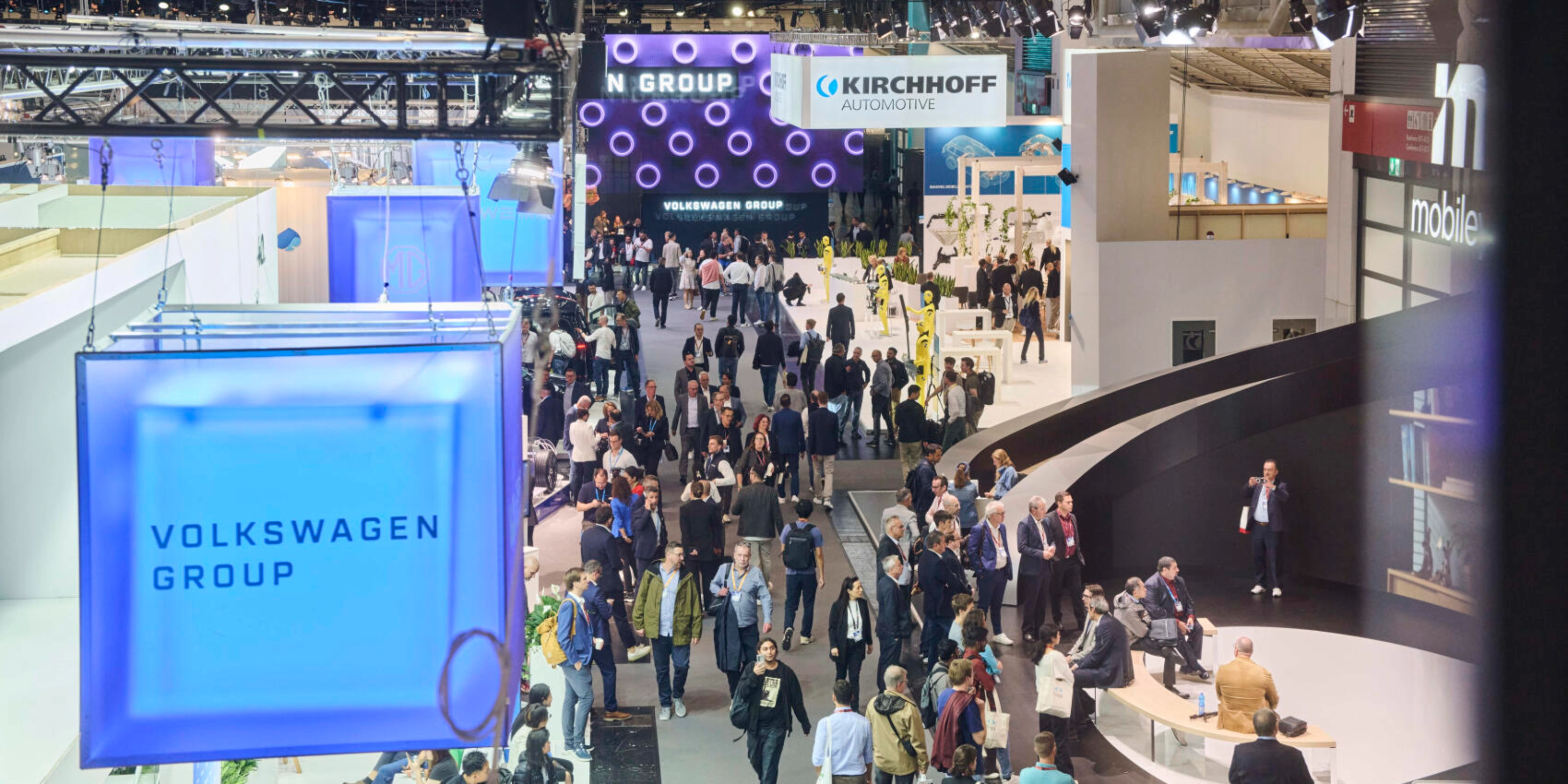 Menschen besuchen den Stand der Volkswagen Group auf einer Messe.