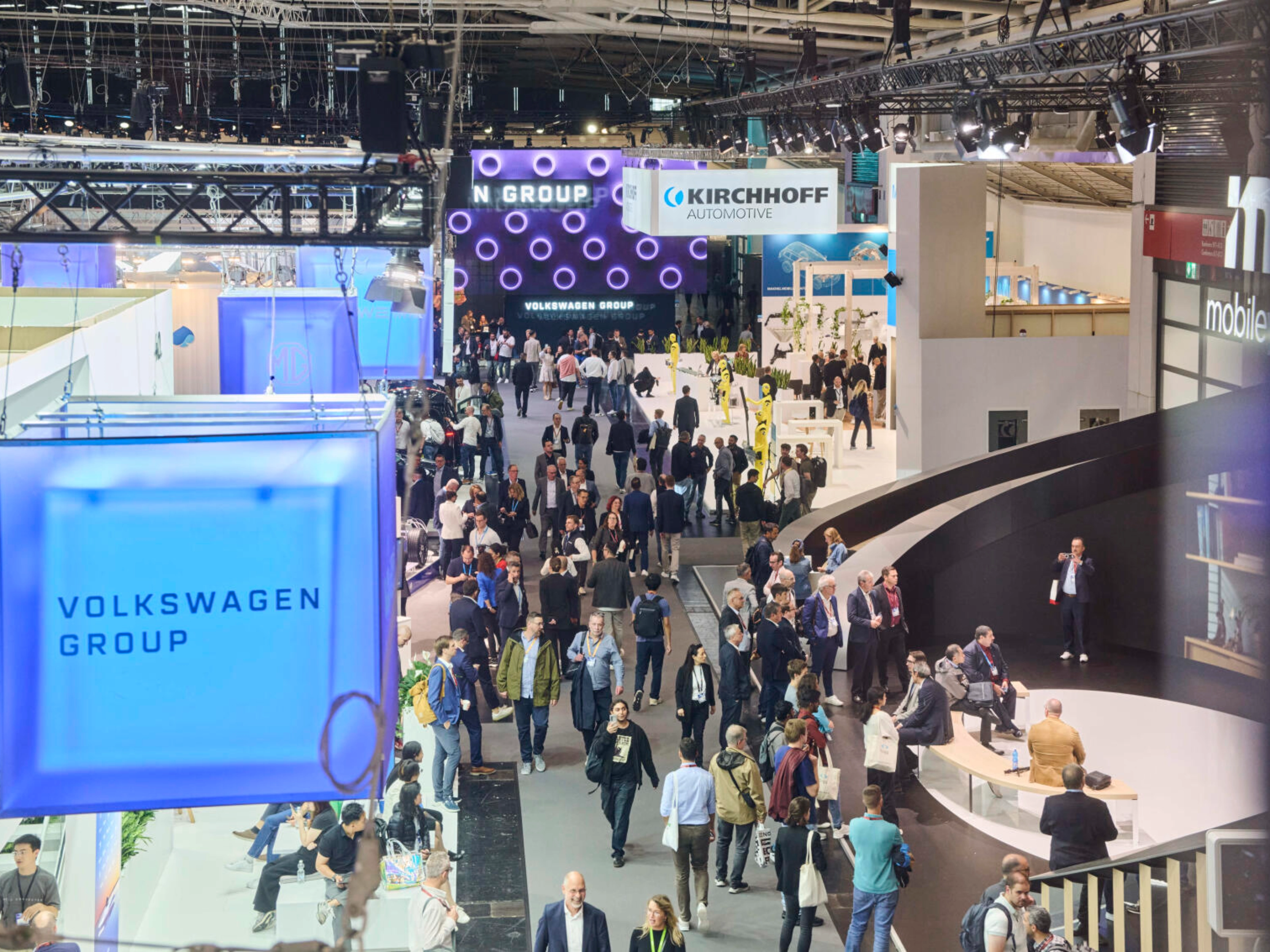 Menschen besuchen den Stand der Volkswagen Group auf einer Messe.