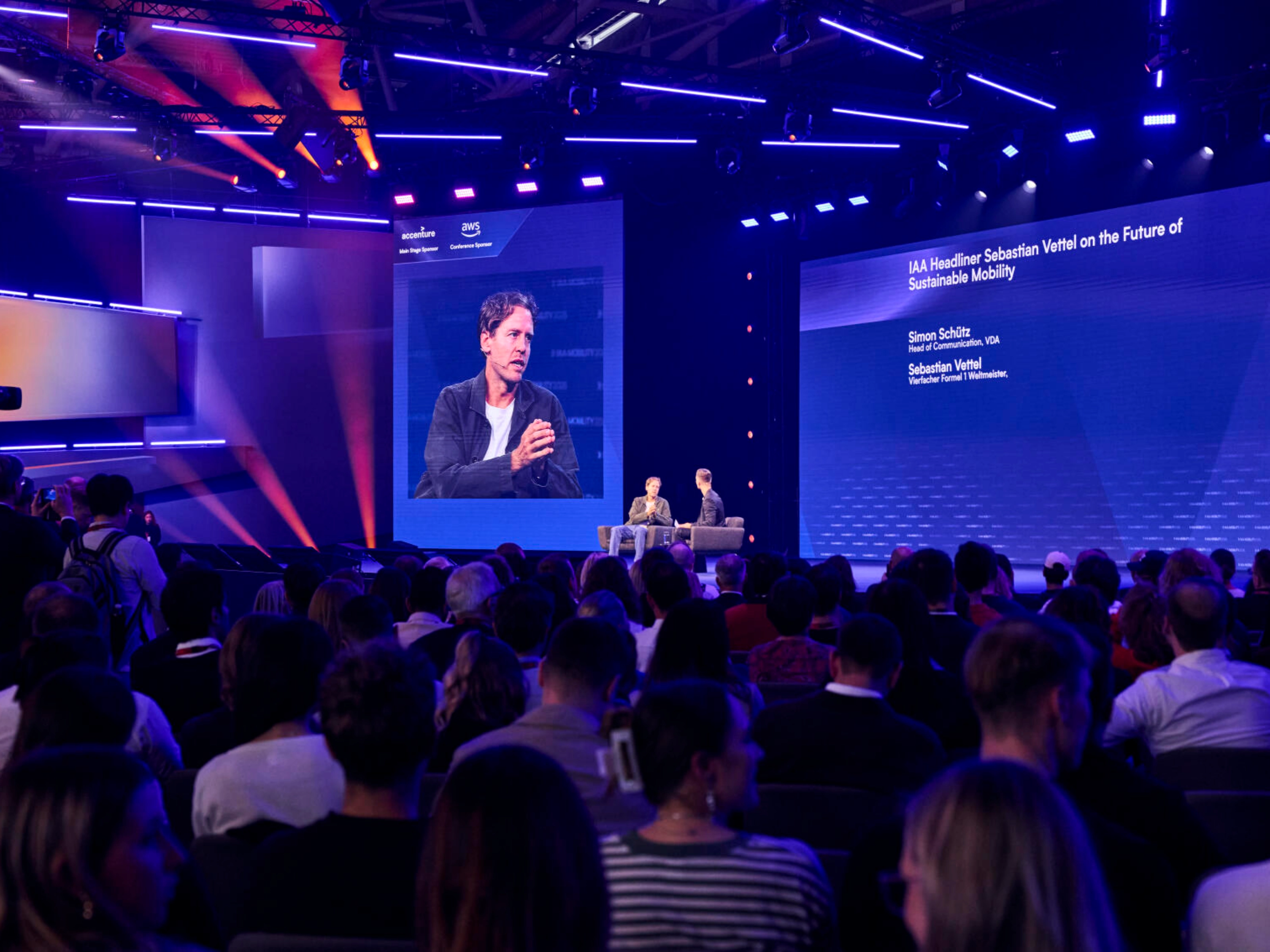 Publikum verfolgt eine Live-Bühnendiskussion zur nachhaltigen Mobilität mit Sebastian Vettel.