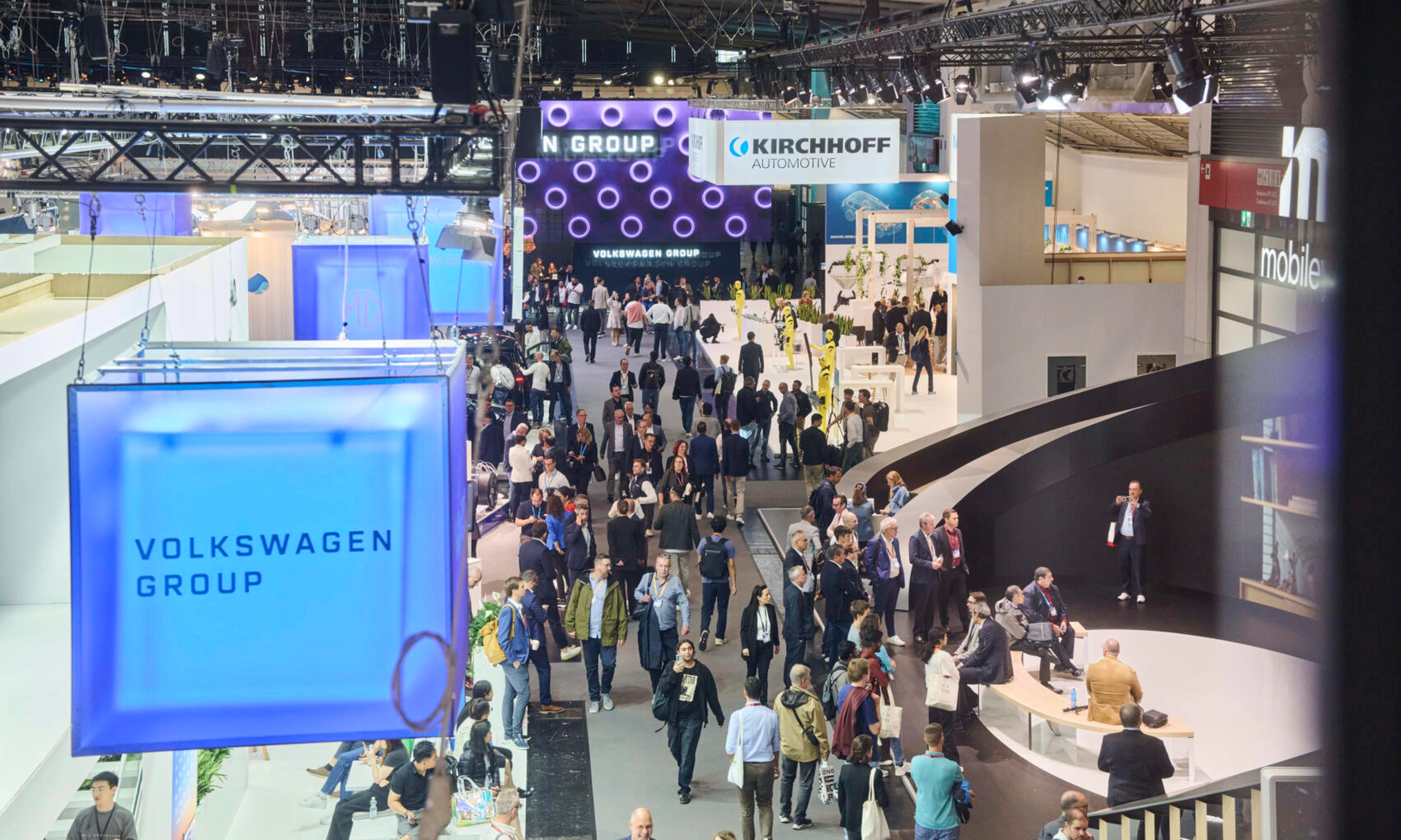Menschen besuchen den Stand der Volkswagen Group auf einer Messe.