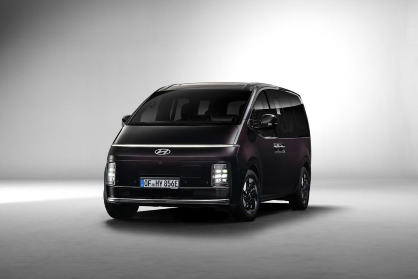 Frontansicht eines schwarzen Hyundai-Vans in einem Studio mit weicher Beleuchtung.