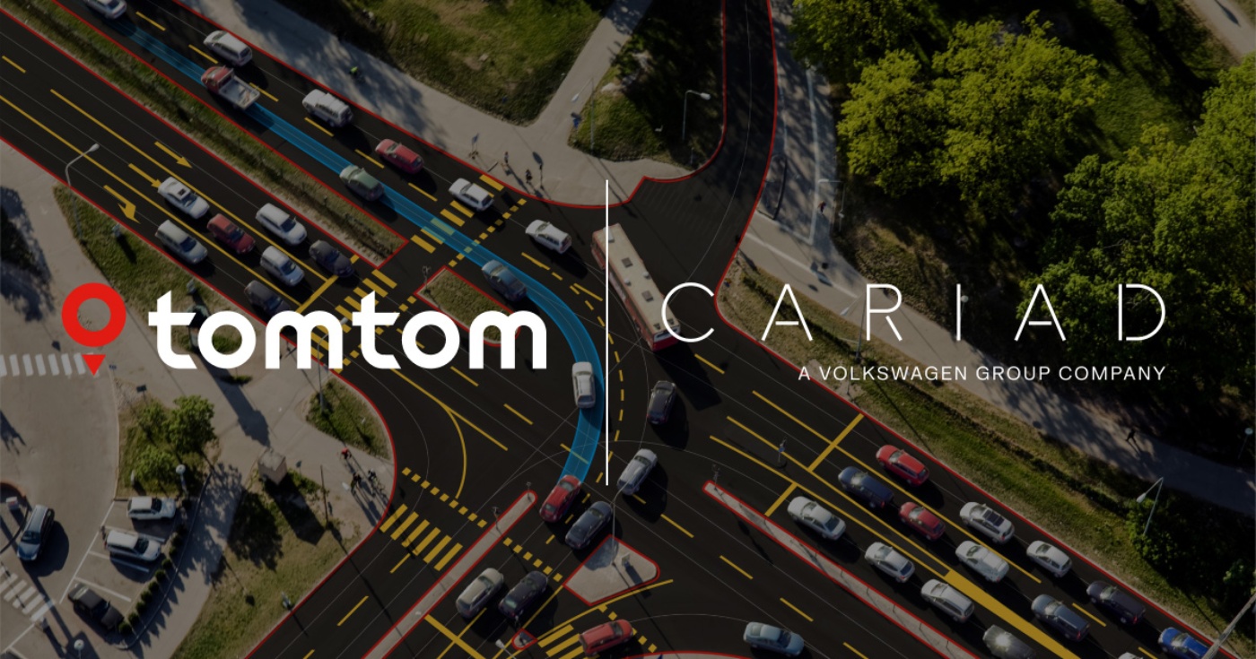 Aerial view of a busy intersection with highlighted navigation paths and logos of TomTom and CARIAD.