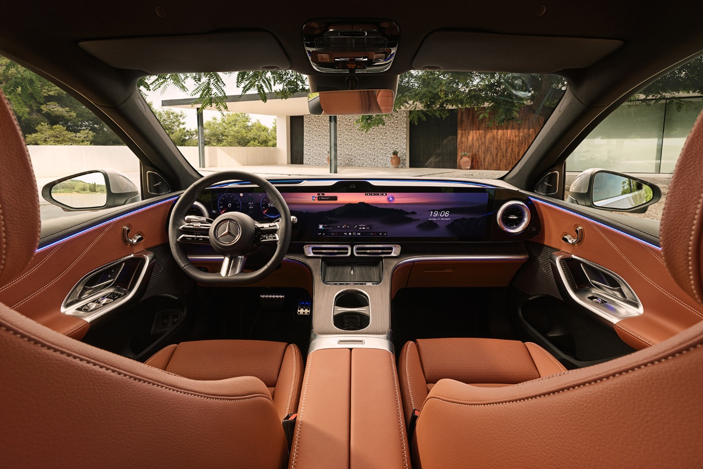 Luxury car cockpit with digital dashboard, leather seats, and wide display screens.