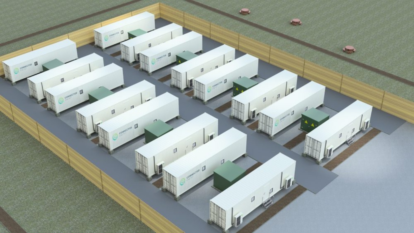 Eingezäunte Anlage mit mehreren weißen Containern zur Energiespeicherung.