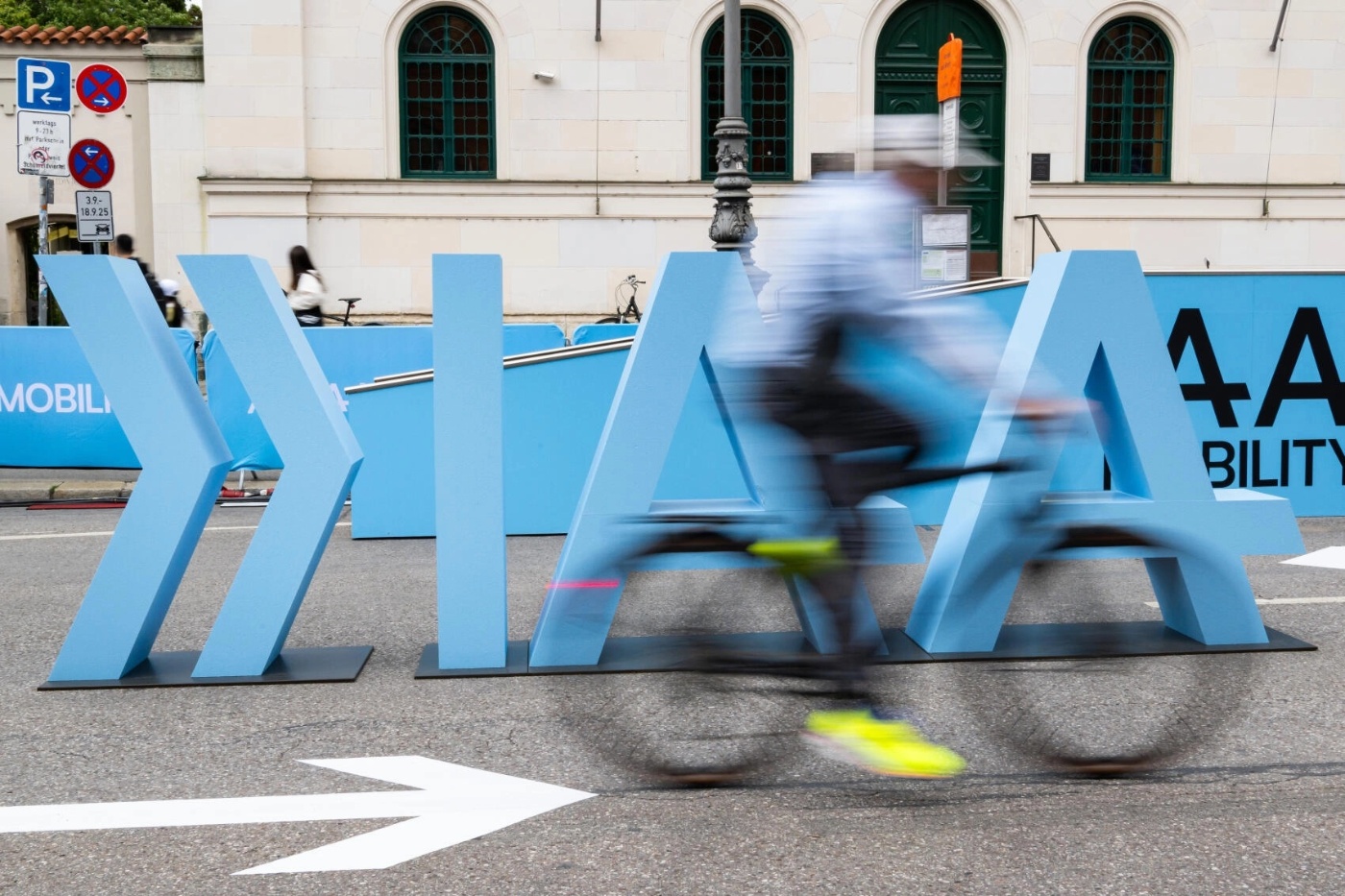Cyclist rides past a mobility installation at an outdoor exhibition.