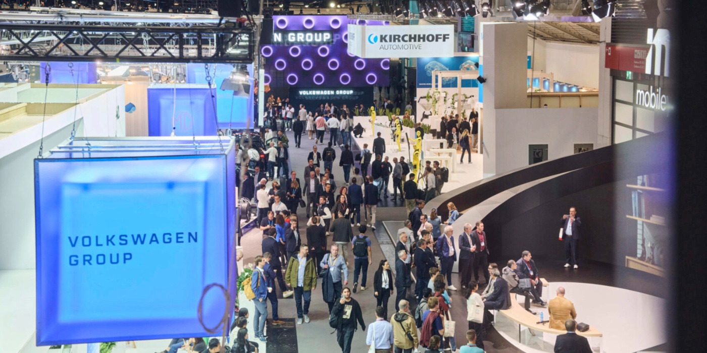 Crowded trade show hall with exhibition booths and visitors.