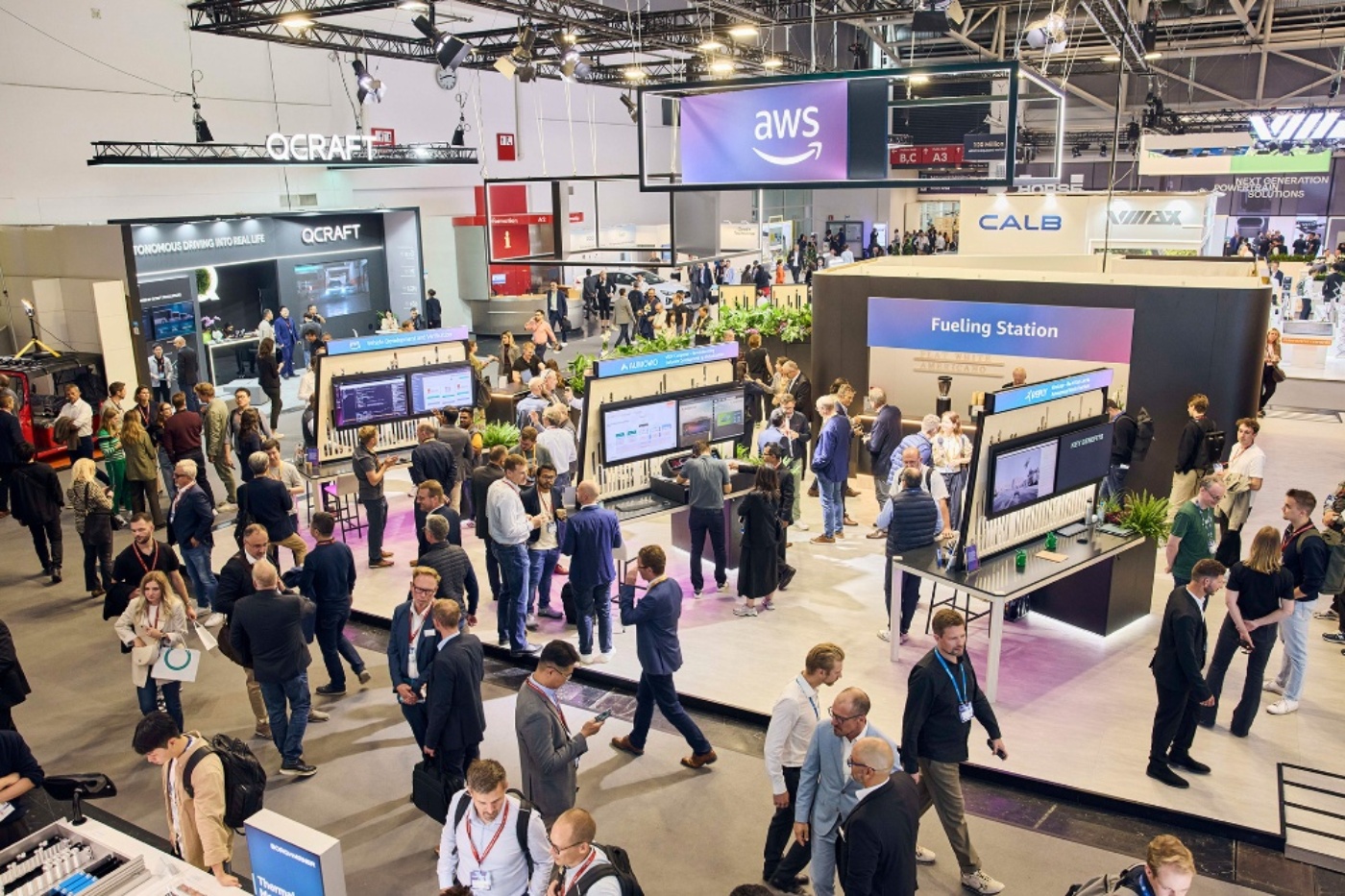 Gut besuchte Messehalle mit Besuchern zwischen verschiedenen Ausstellungsständen.