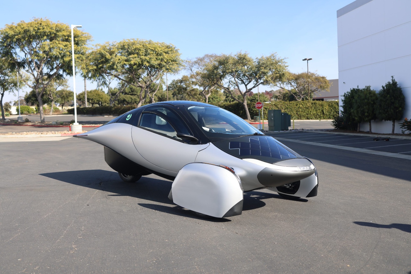 Das solarbetriebene Dreirad von Aptera parkt im Freien und zeigt sein aerodynamisches Design.