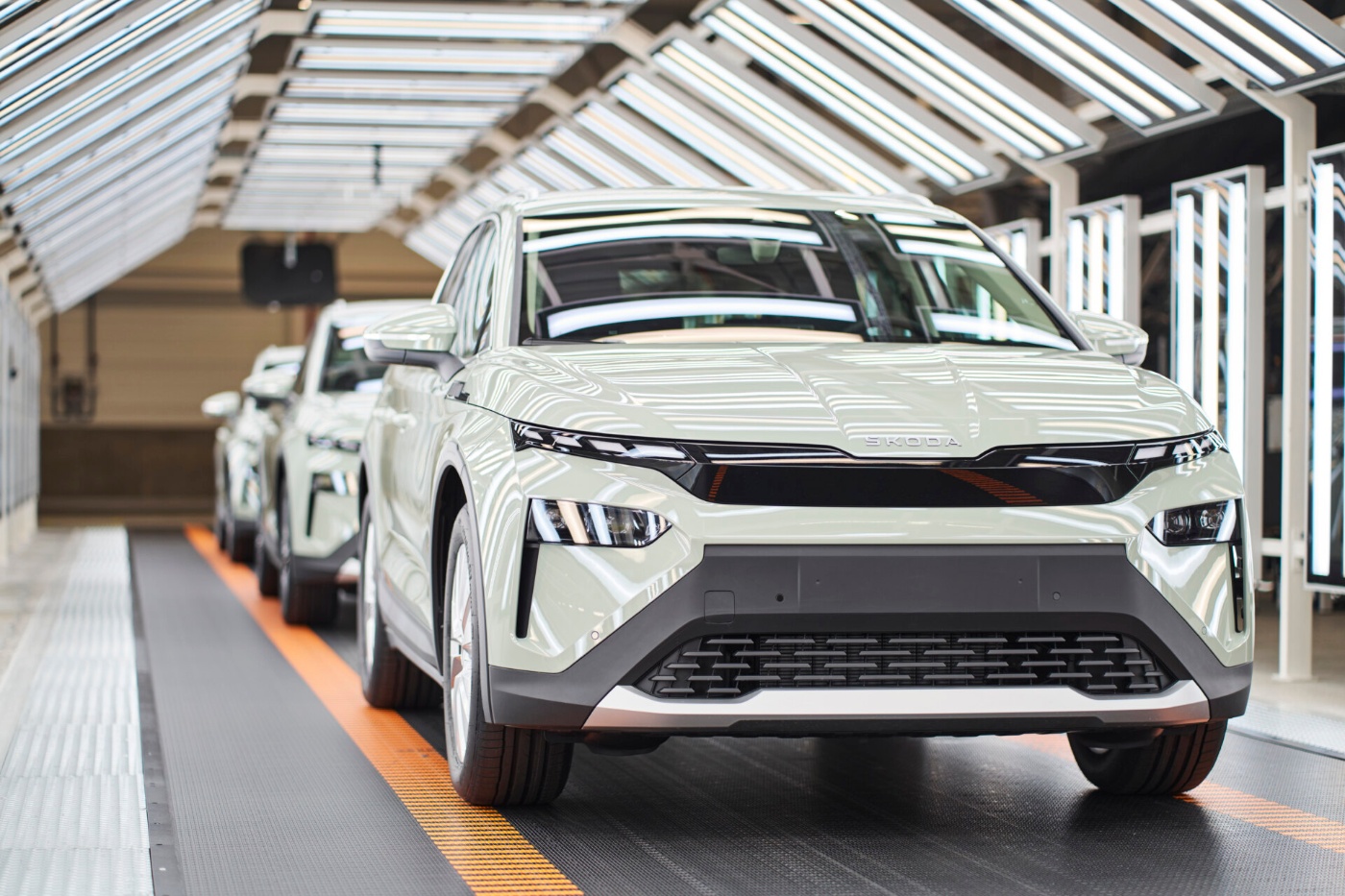 A Skoda Elroq in a production hall, surrounded by manufacturing equipment.