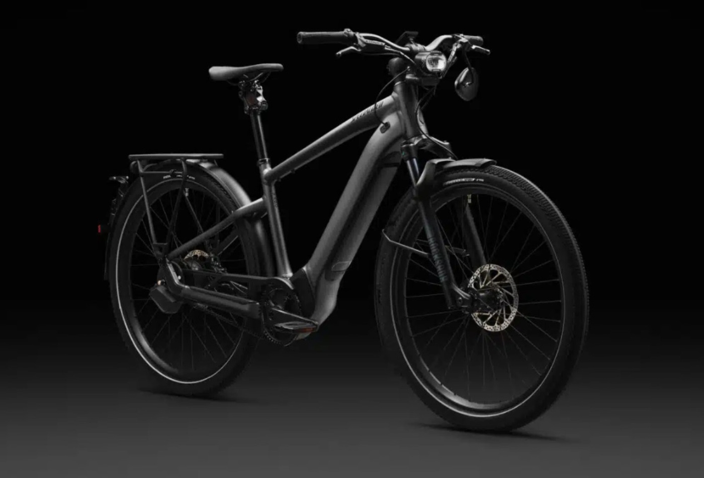 Side-front view of a sleek black electric bicycle with disc brakes and integrated lights, displayed against a dark background.