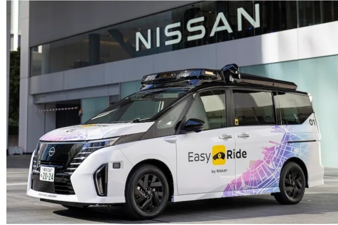 Self-driving shuttle van with Easy Ride branding parked in front of a Nissan building.