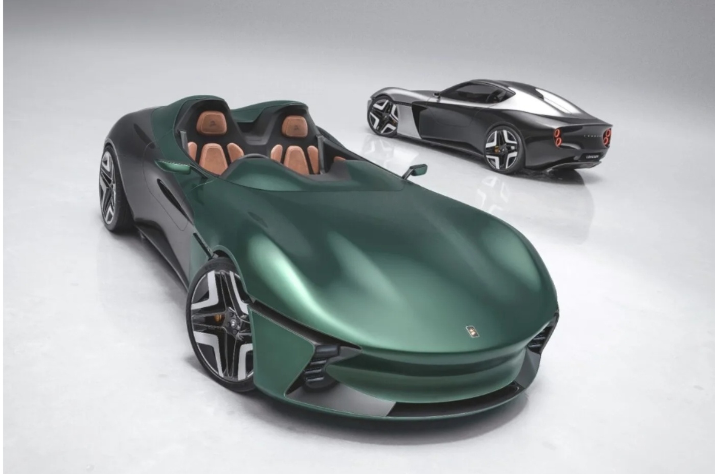 Two futuristic concept cars in a studio setting, one green open-top