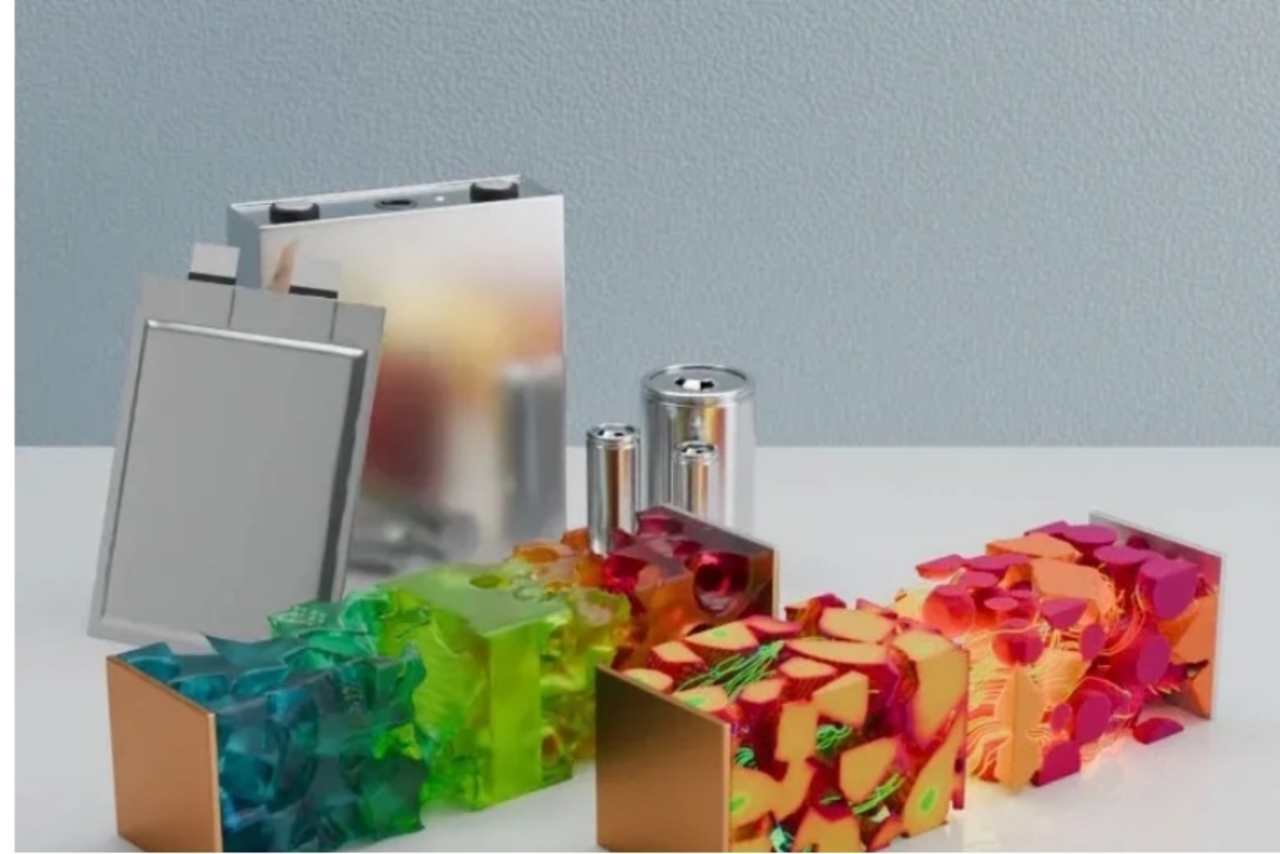 Verschiedene Batteriezellen und farbige 3D-Modelle innerer Zellstrukturen liegen auf einer weißen Fläche.