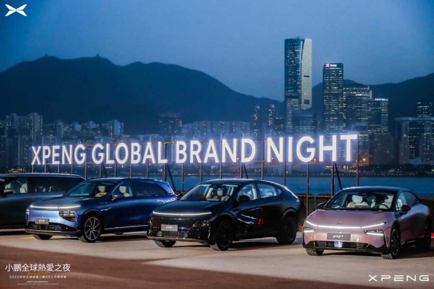 Vier Elektrofahrzeuge von XPeng stehen nachts vor einem beleuchteten Schriftzug „XPENG GLOBAL BRAND NIGHT“, im Hintergrund sind eine Skyline und Berge zu sehen.