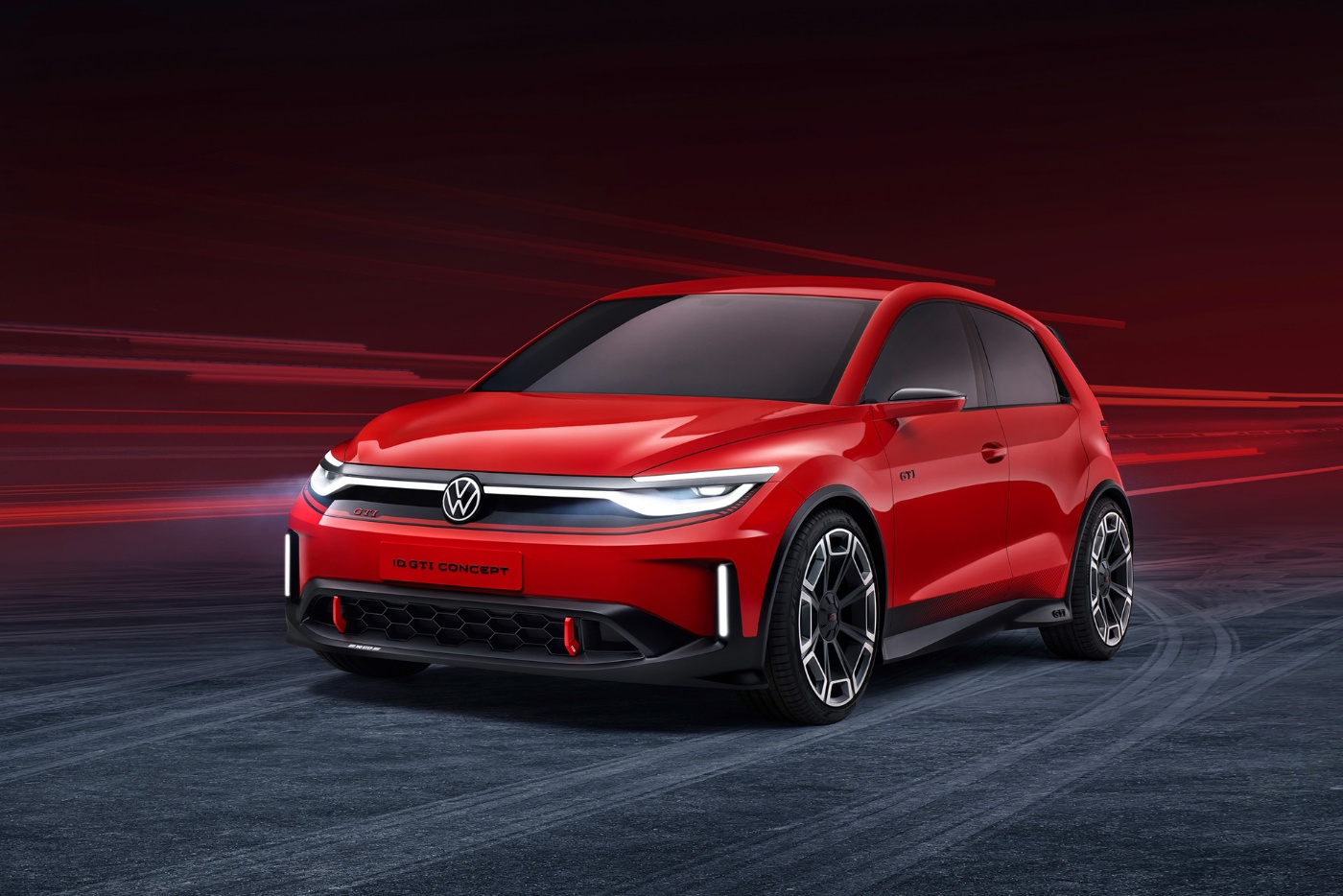 Ein rotes elektrisches Volkswagen-Konzeptauto mit sportlichem Design, von vorne links vor dynamischem roten Hintergrund gezeigt.