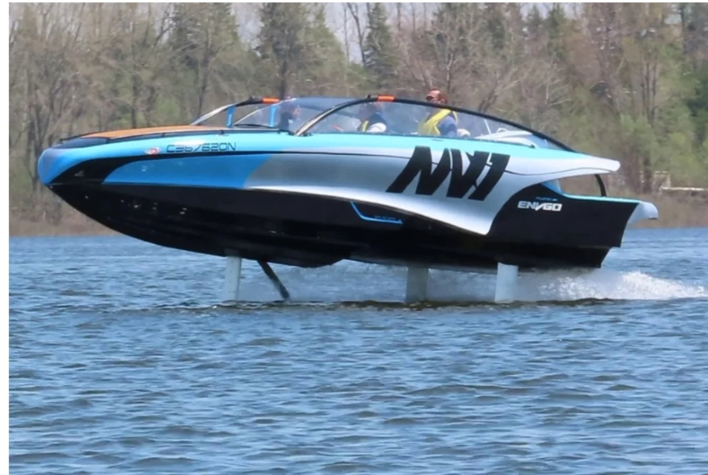 Ein futuristisches elektrisches Tragflächenboot gleitet mit Passagieren über die Wasseroberfläche, im Hintergrund Bäume.