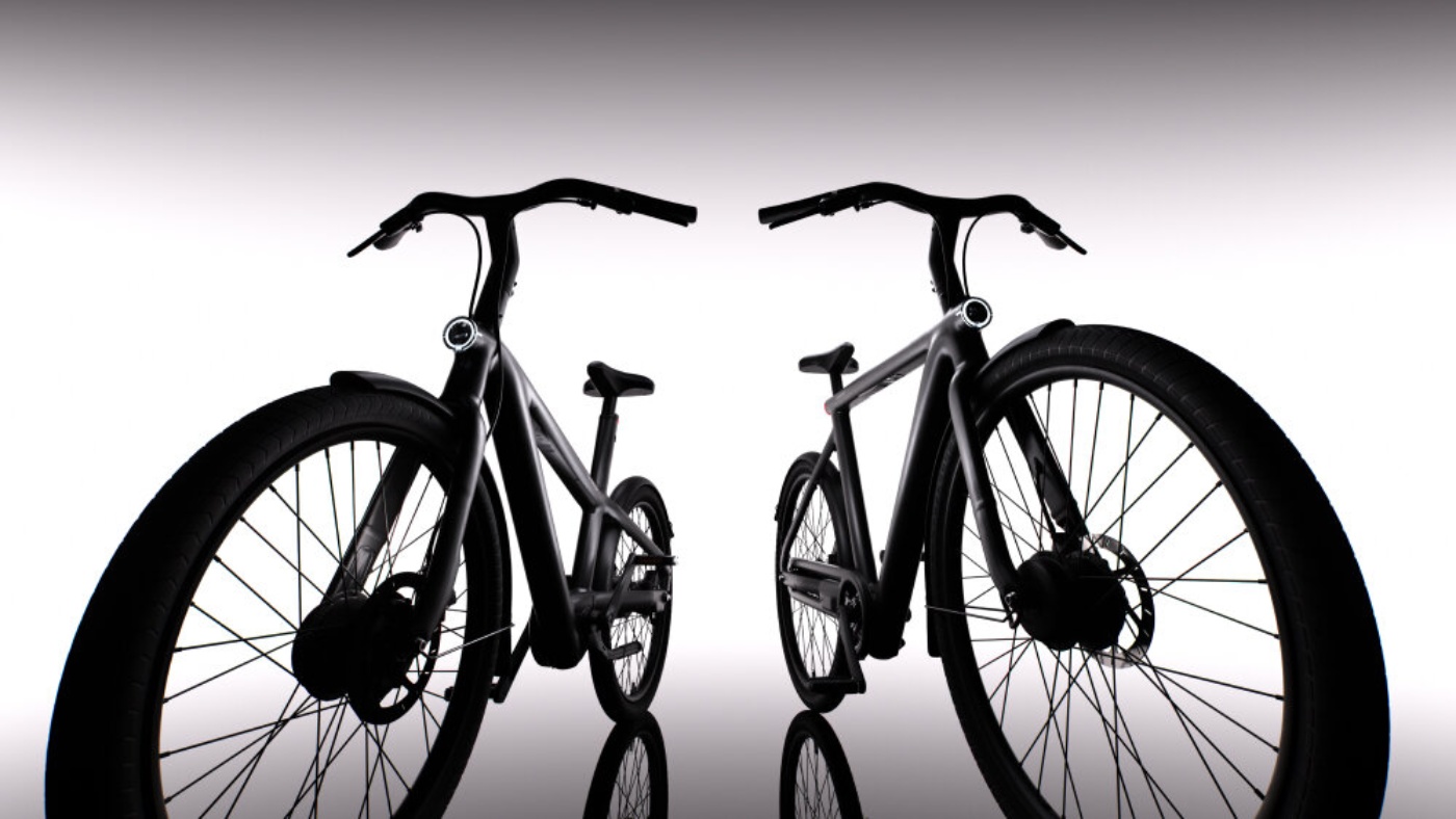 Zwei moderne E-Bikes stehen sich in einem Studio mit starker Beleuchtung und Spiegelung gegenüber.