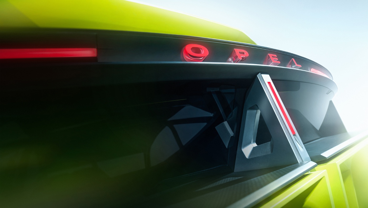 Close-up of a futuristic Opel concept car with illuminated logo and sharp design elements.