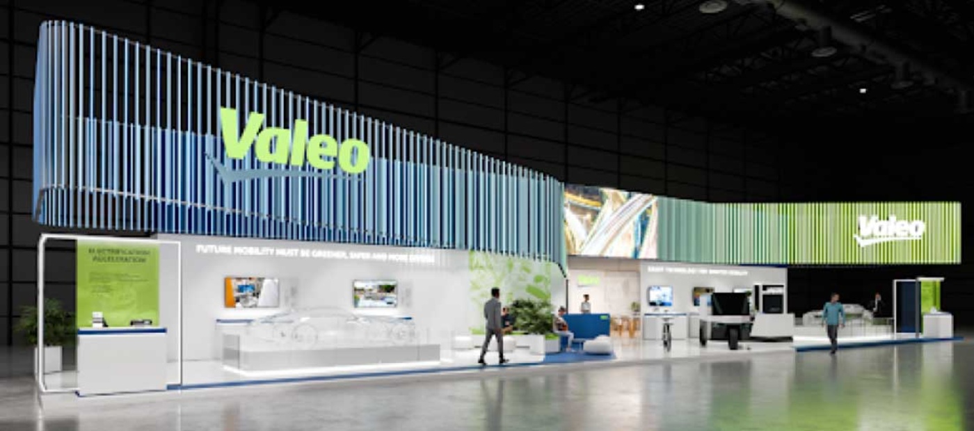 Large Valeo exhibition booth with displays and tech models at an indoor trade fair.