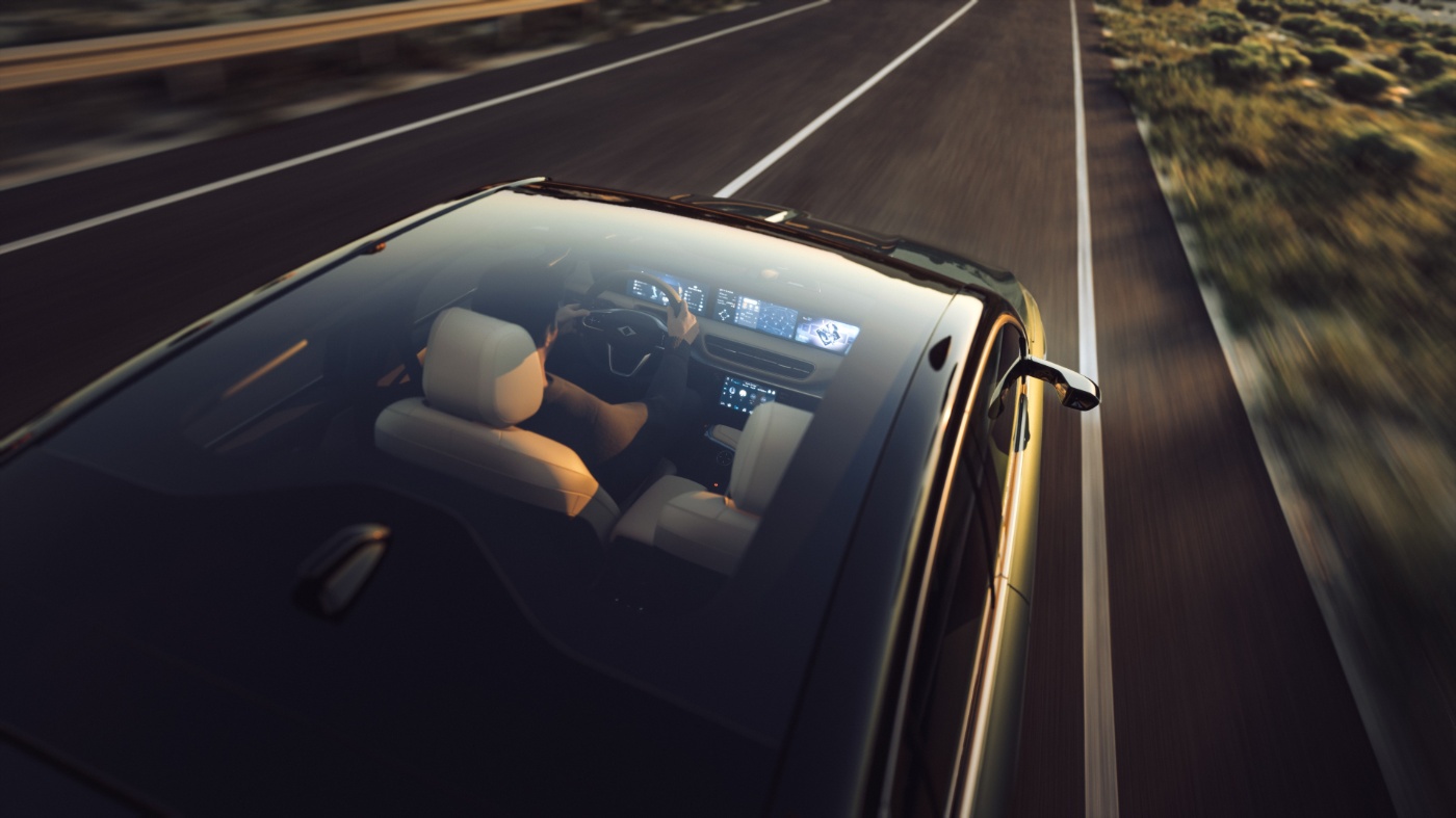 Blick durch das Glasdach eines fahrenden Autos mit Fahrer und digitalem Armaturenbrett auf offener Straße.