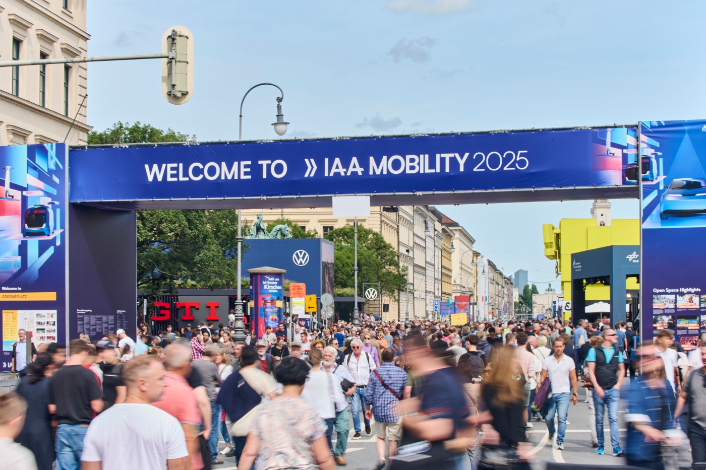 Menschenmenge betritt die IAA Mobility 2025 unter einem großen Willkommensbanner in der Stadt.