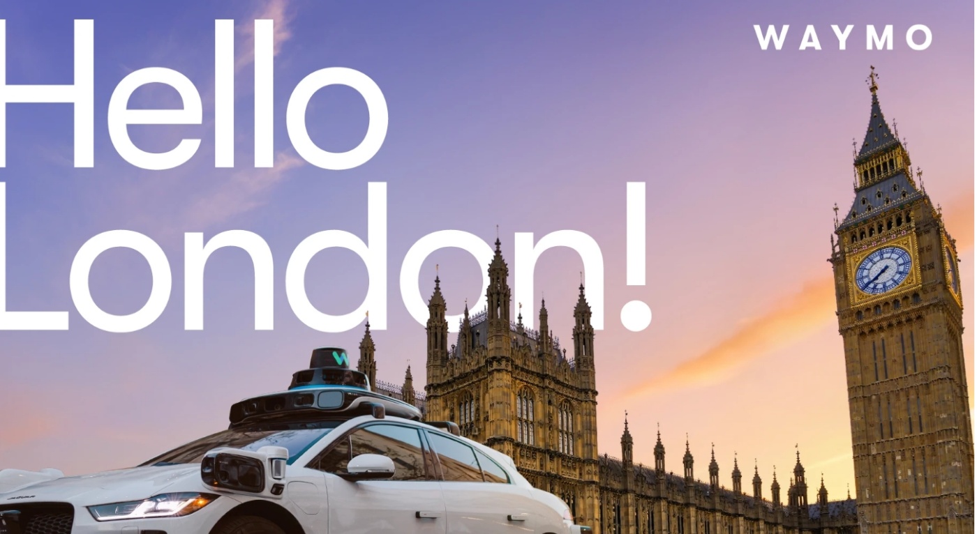 Self-driving Waymo car in front of Big Ben with text “Hello London!” at sunset.